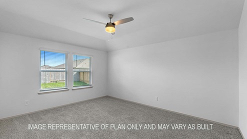 Cali primary bedroom with windows and carpet flooring.