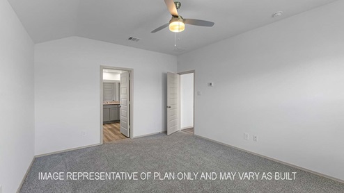 Cali primary bedroom with carpet flooring and view of primary bathroom.