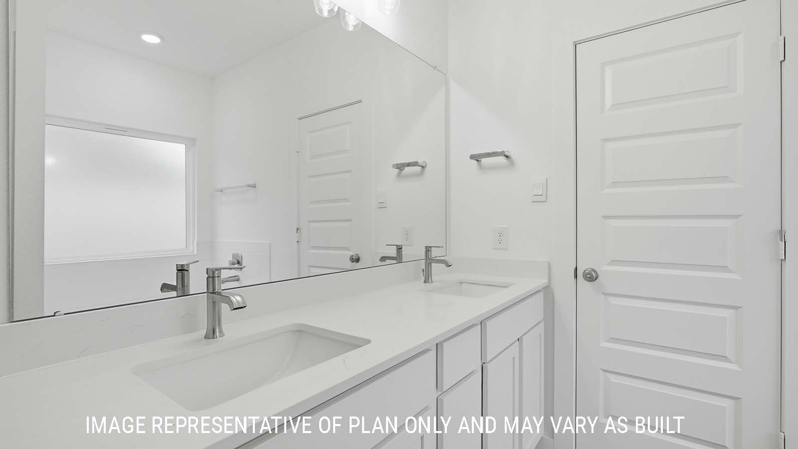 Berkshire primary bathroom with double vanity sink with white countertops and mirror.