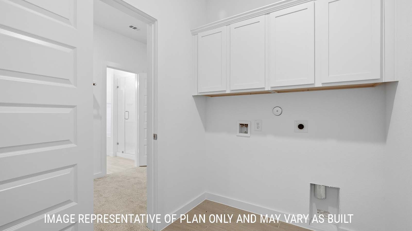 Berkshire utility room with washer and dryer connections and white cabinets for storage.