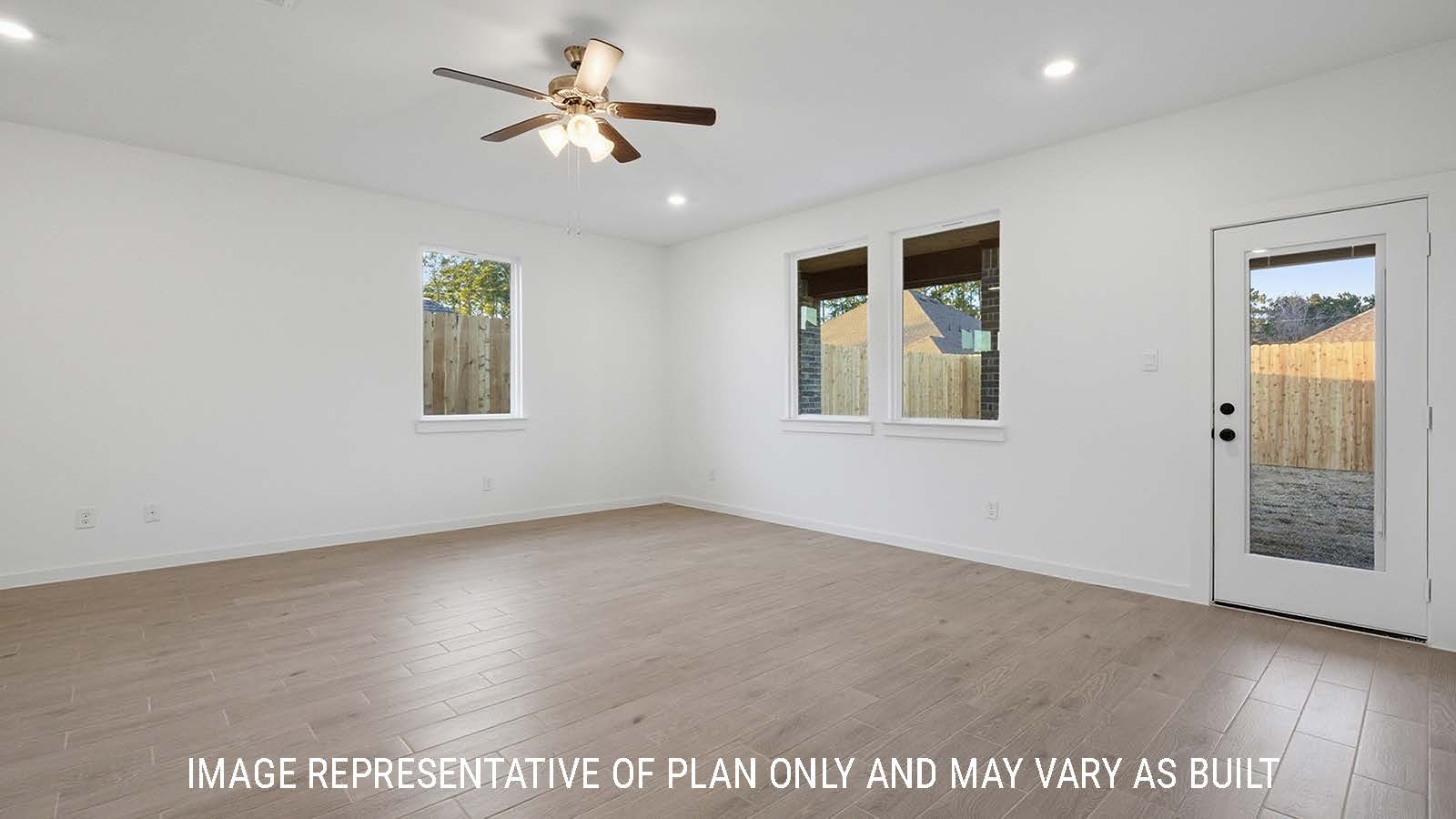Newburgh living room with vinyl plank flooring and windows for natural lighting and view of backyard.