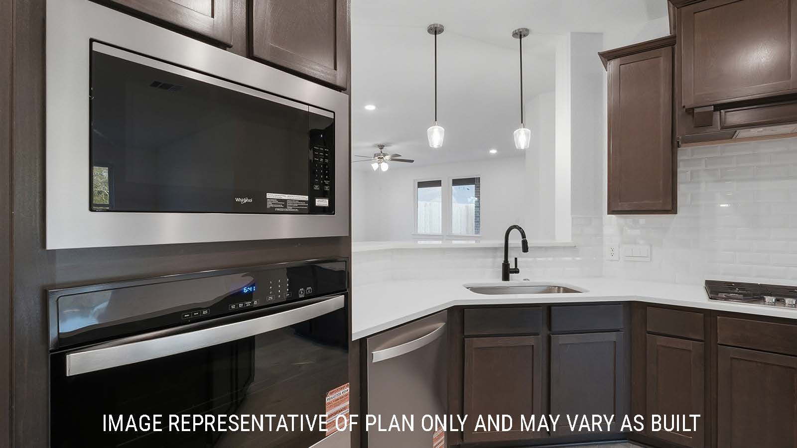 Newburgh kitchen with dark cabinets and white countertops and view of living room.