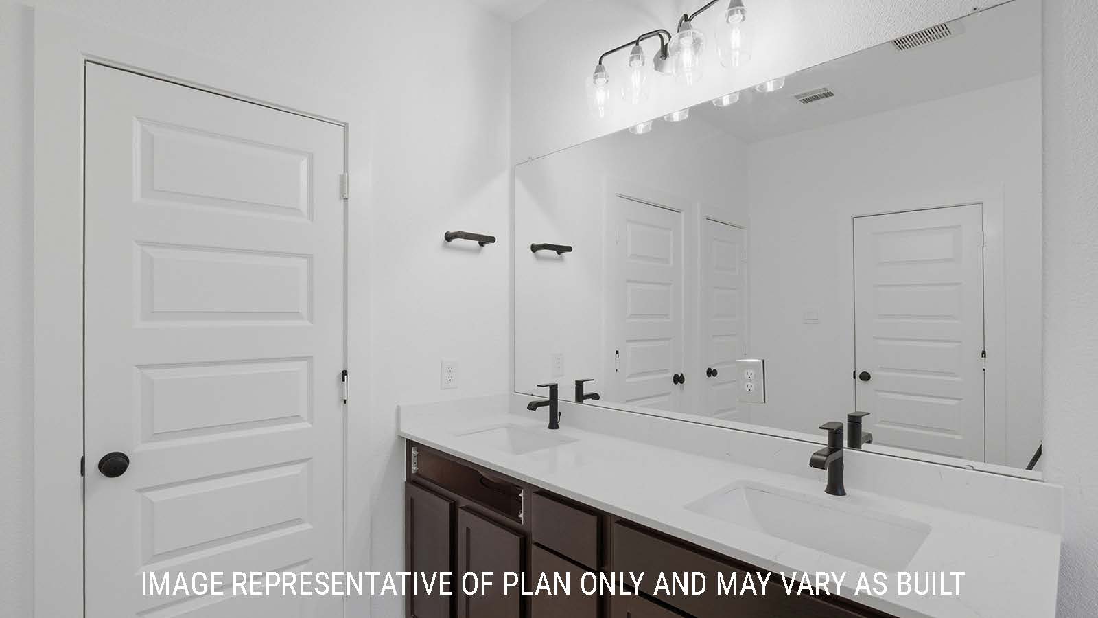 Newburgh primary bathroom with double vanity sink with dark cabinets and white countertops.