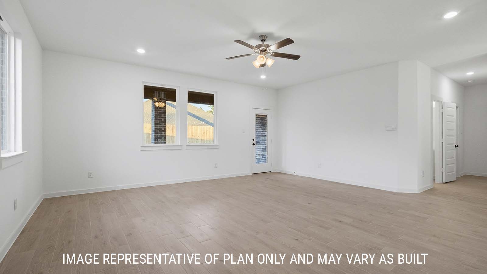 Newburgh living room with vinyl plank flooring and windows for natural lighting and view of backyard.