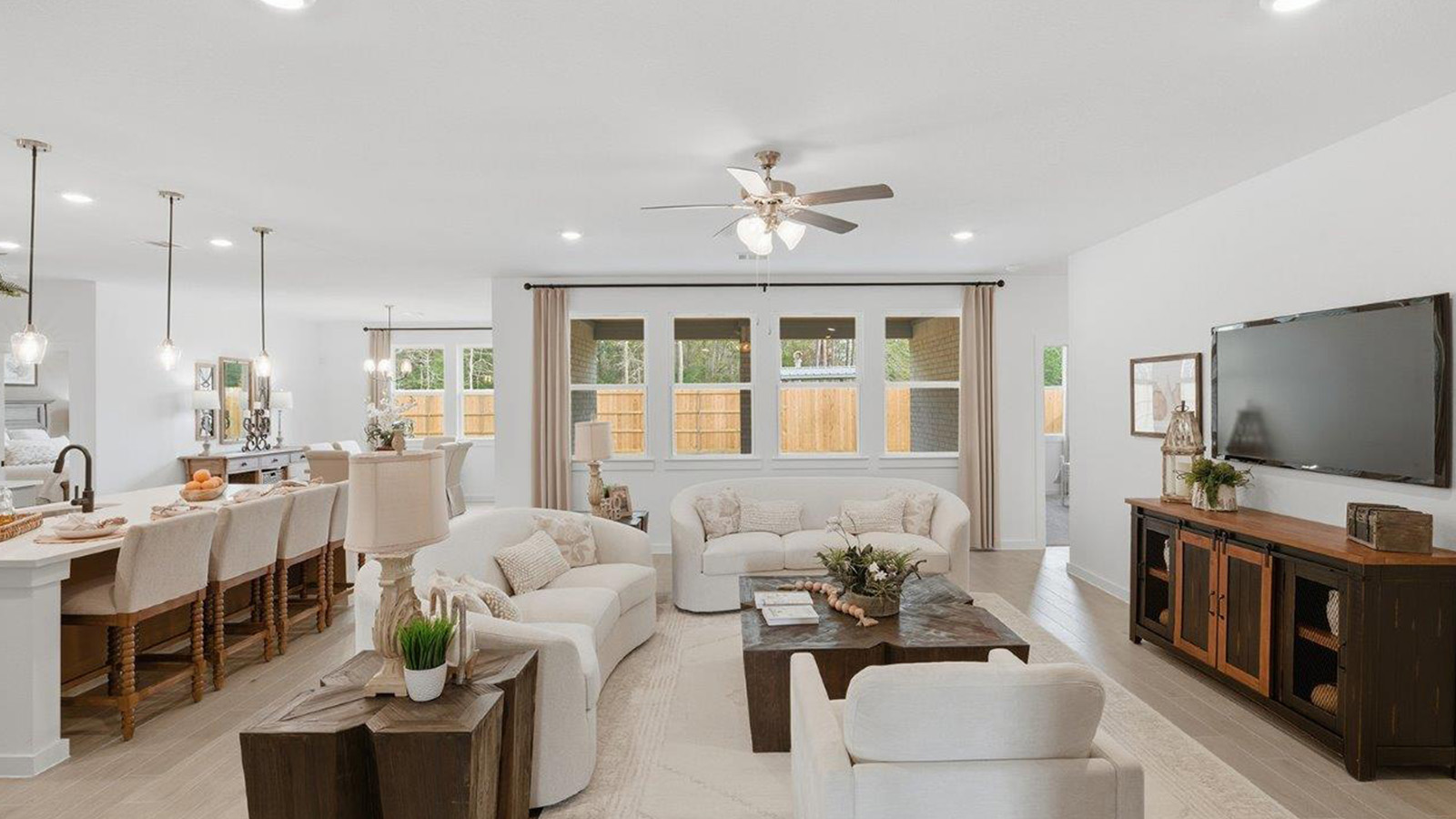 The woods model home living room with view of open concept kitchen and dining room.