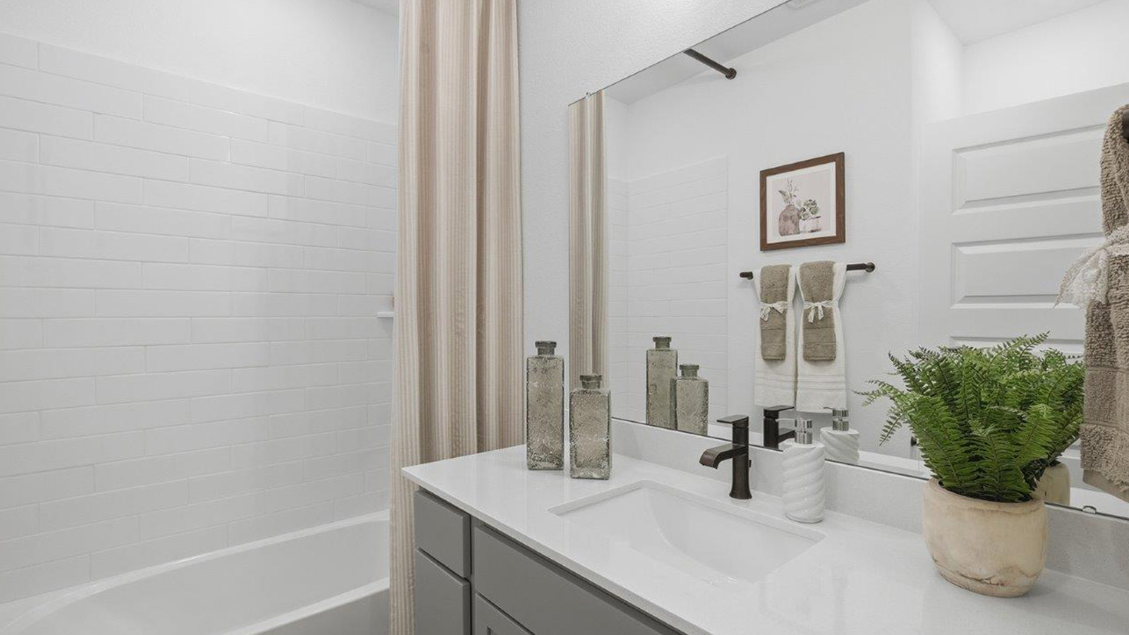 The woods model home secondary bathroom with vanity sink and shower and tub combo.