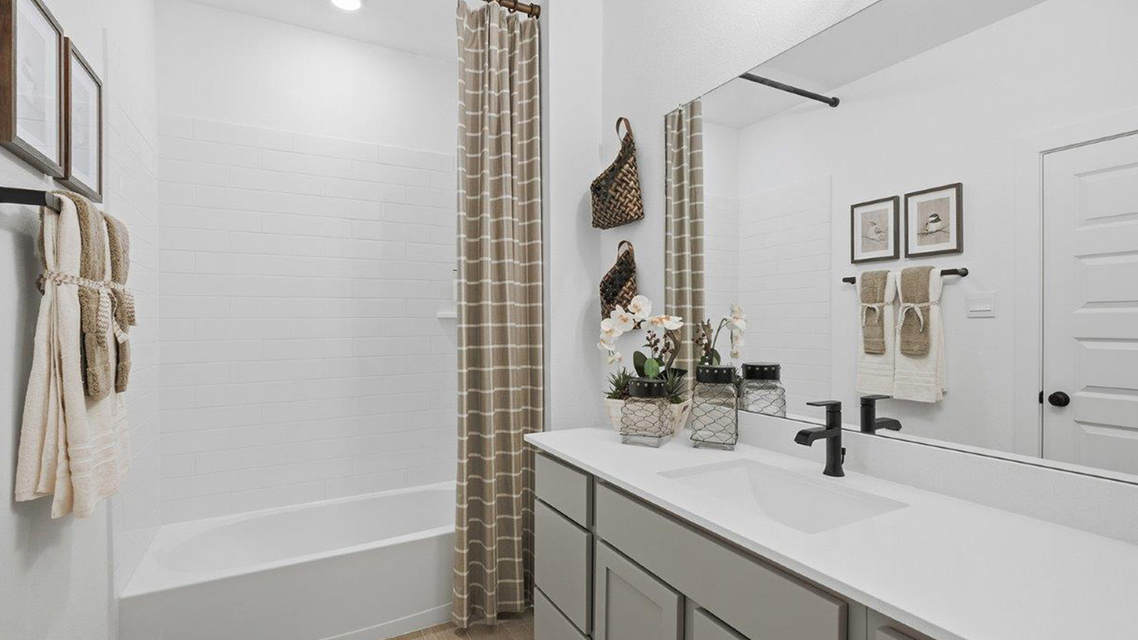 The woods model home secondary bathroom with vanity sink and shower and tub combo.