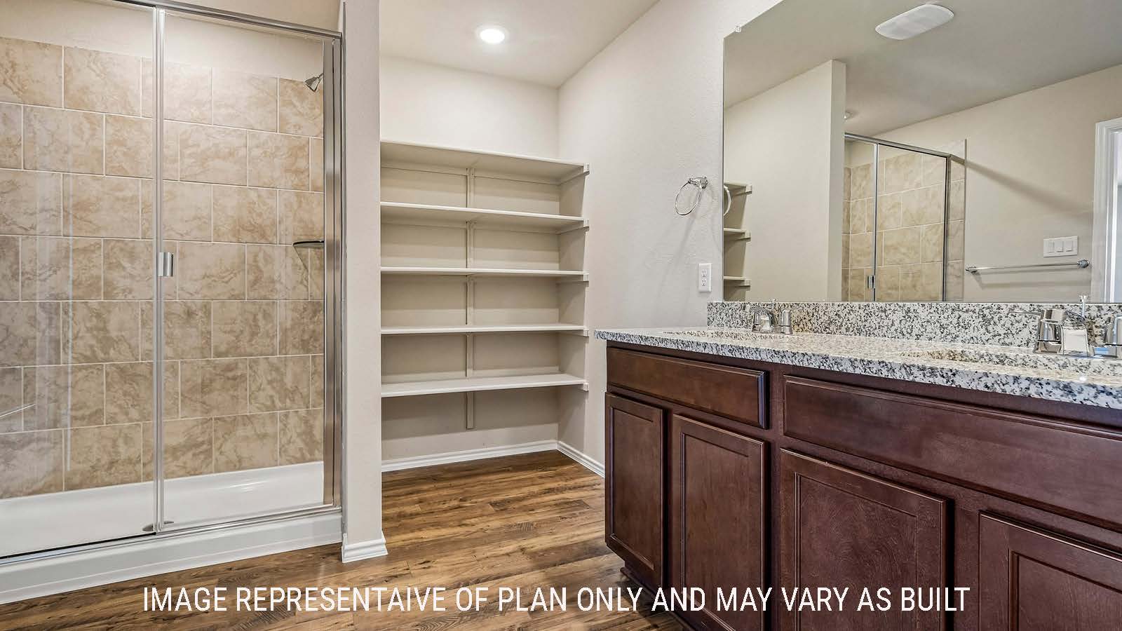 Prosper primary bathroom with double vanity and walk-in shower.