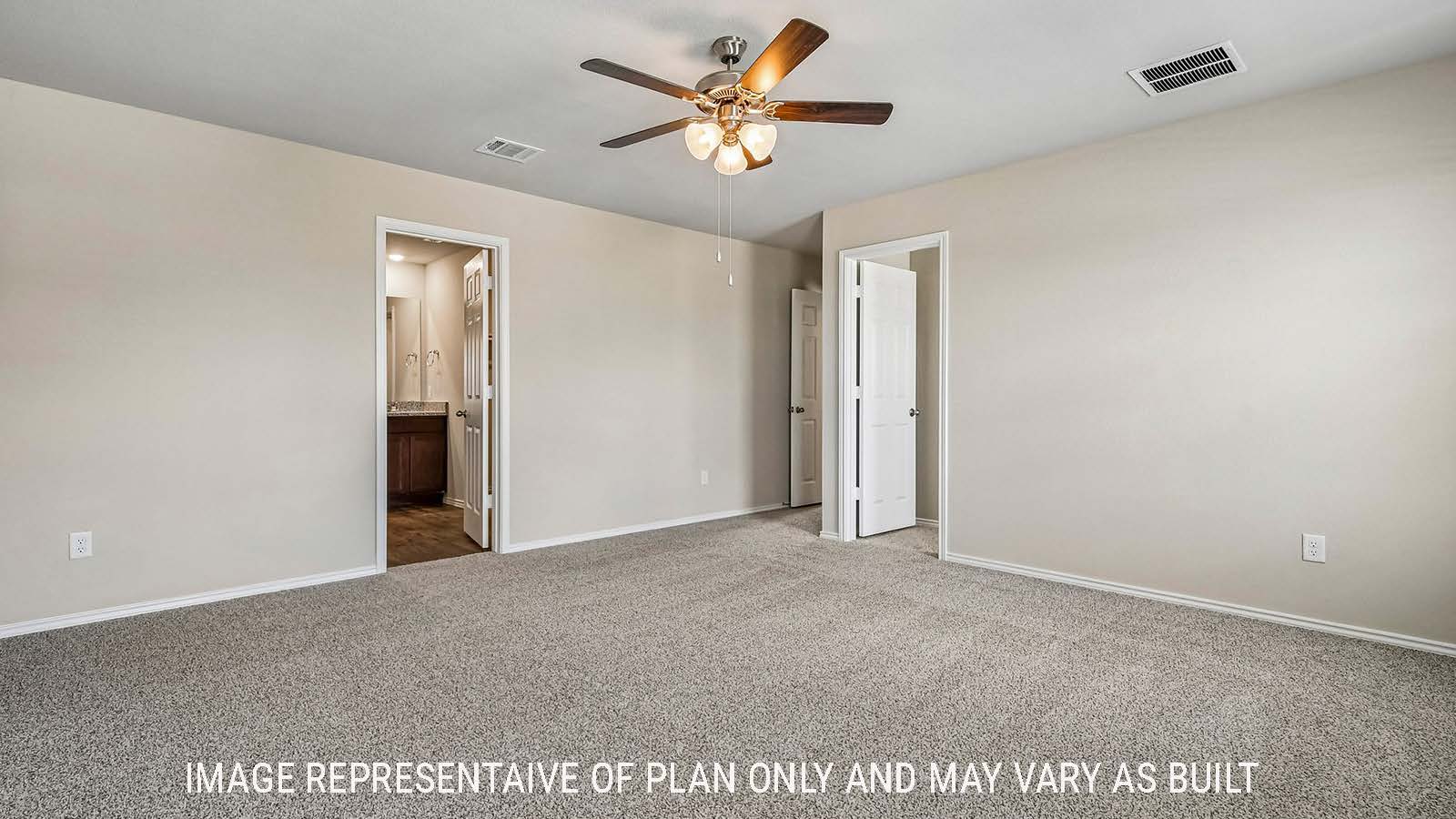 Prosper primary bedroom with carpeted flooring and view of primary bathroom.