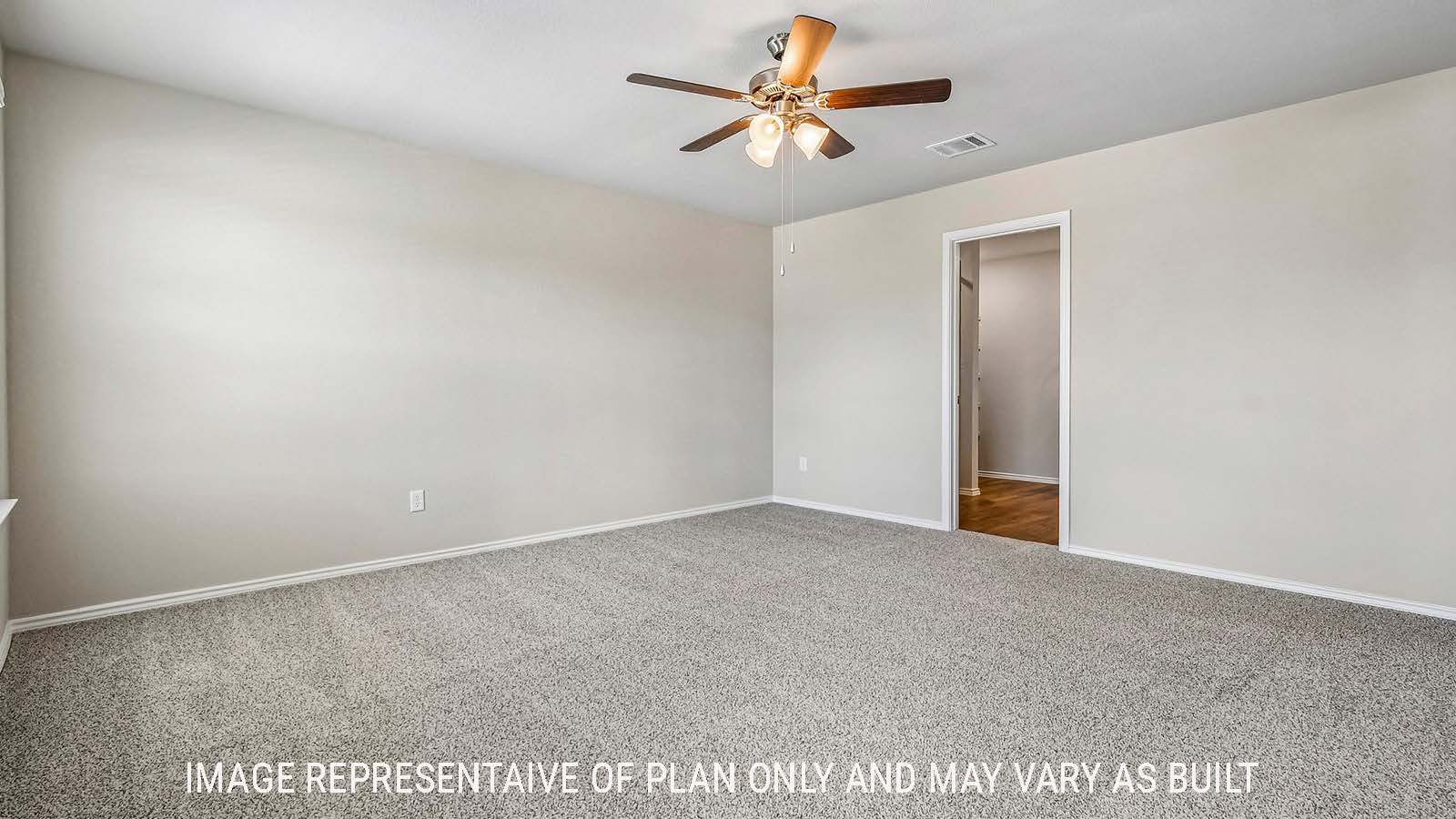 Prosper primary bedroom with carpeted flooring and view of primary bathroom.