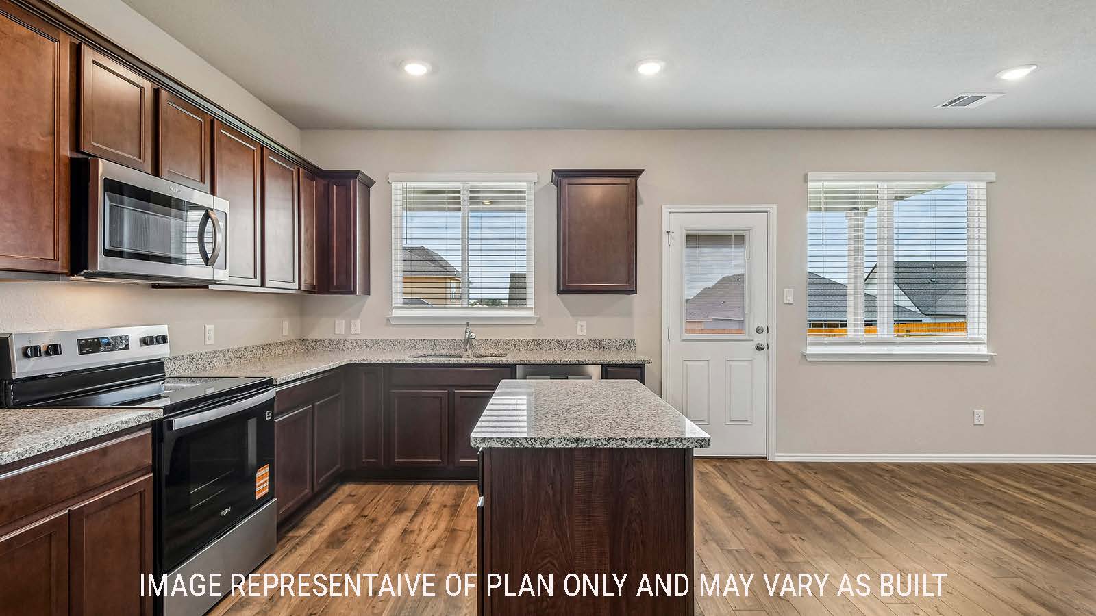 Prosper kitchen with kitchen island and dark cabinets with windows for natural lighting.