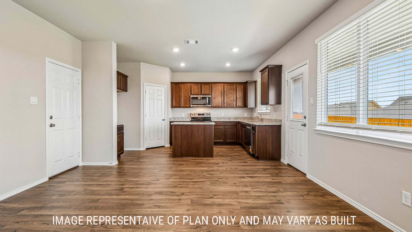 Prosper dining room with view of open concept kitchen and windows for natural lighting.
