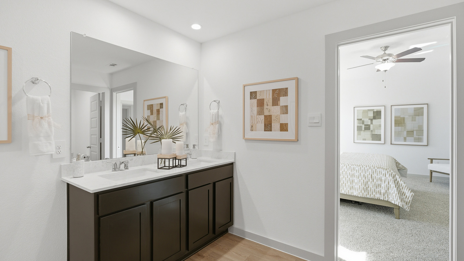 Highland Village model home primary bathroom with vanity sink and view of primary bedroom.