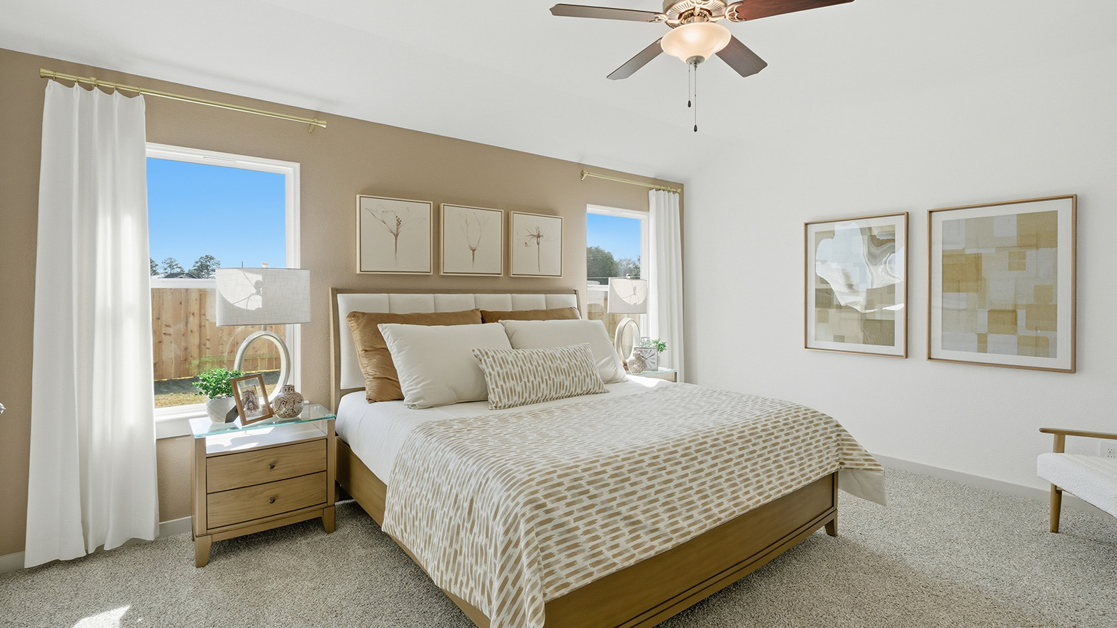 Highland Village model home primary bedroom with carpeted flooring and windows for natural lighting.