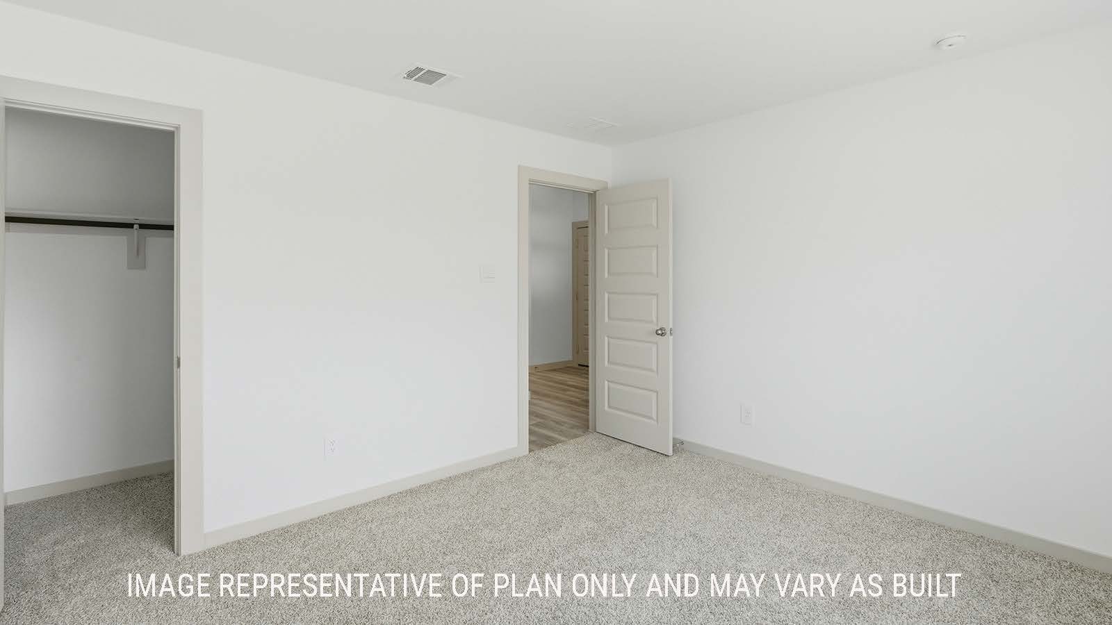 Elgin secondary bedroom with carpeted flooring and view of hallway to kitchen.