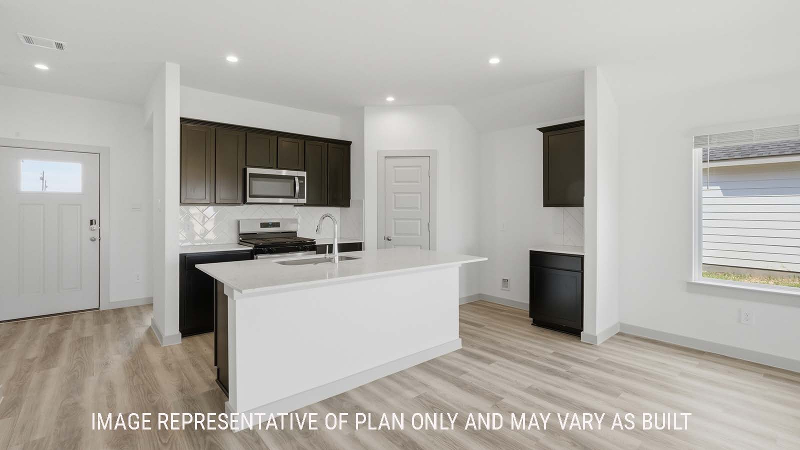 Elgin kitchen with kitchen island with grainite countertops and vies of front entry way.