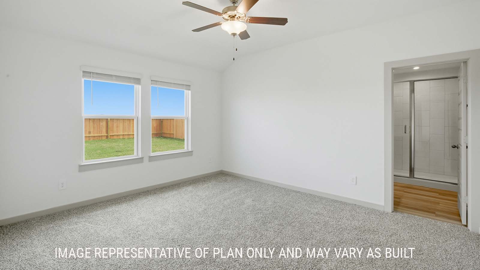 Elgin primary bedroom with carpeted flooring and view of primary bathroom.