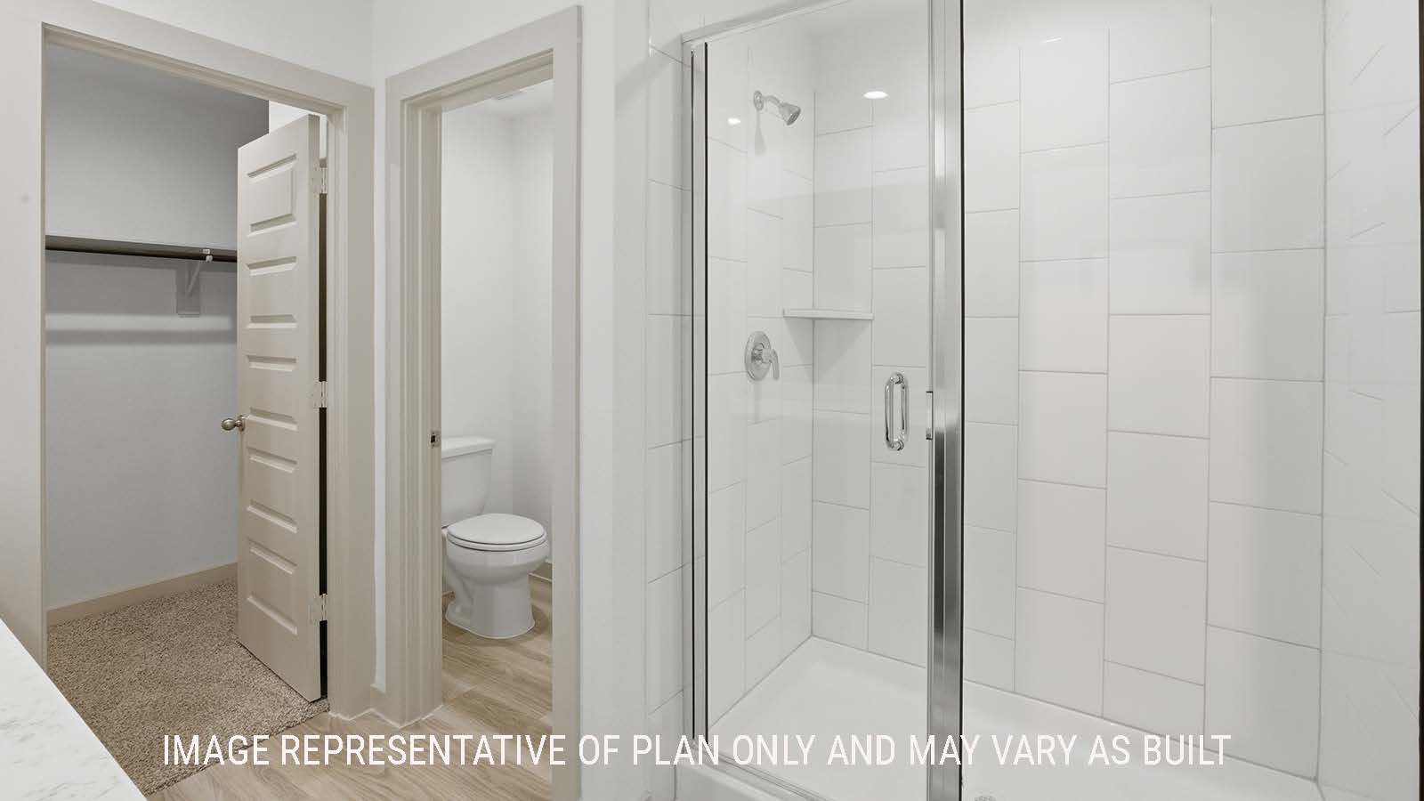 Elgin primary bathroom with dual vanity sink and view of primary bedroom walk-in closet.