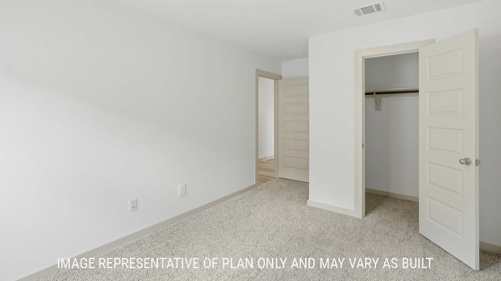 Elgin secondary bedroom with carpeted flooring and view of hallway to kitchen.