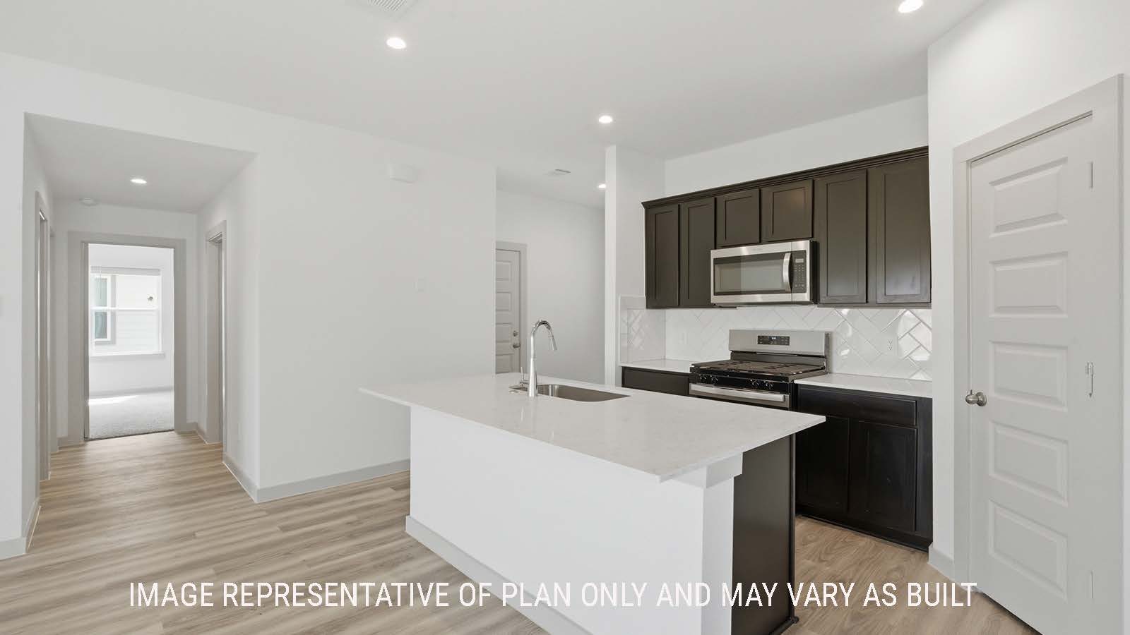 Elgin kitchen with kitchen island with granite countertops and dark cabinets with view of secondary bedrooms.