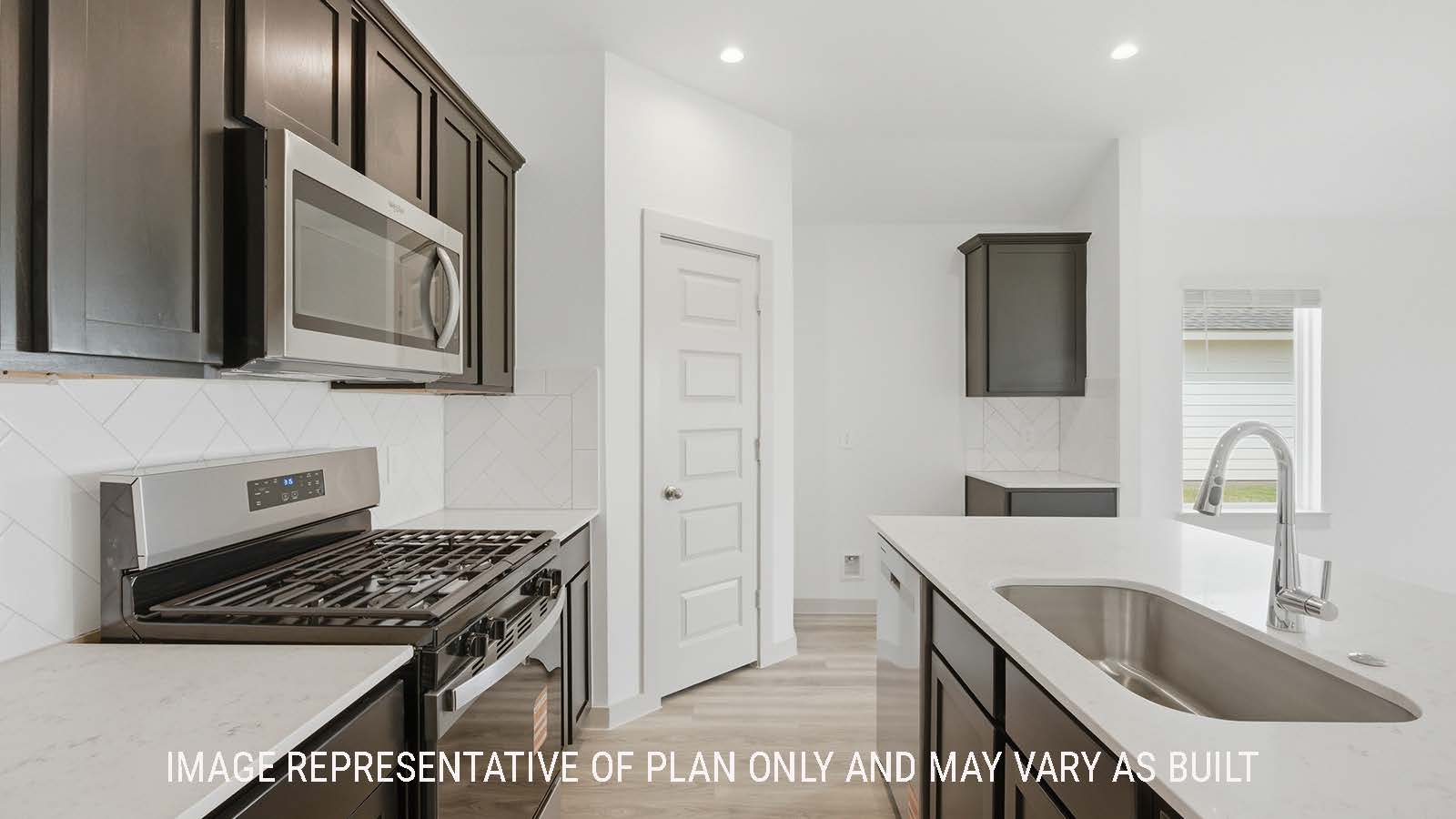 Elgin kitchen with granite countertops and dark cabinets with view of pantry door way.
