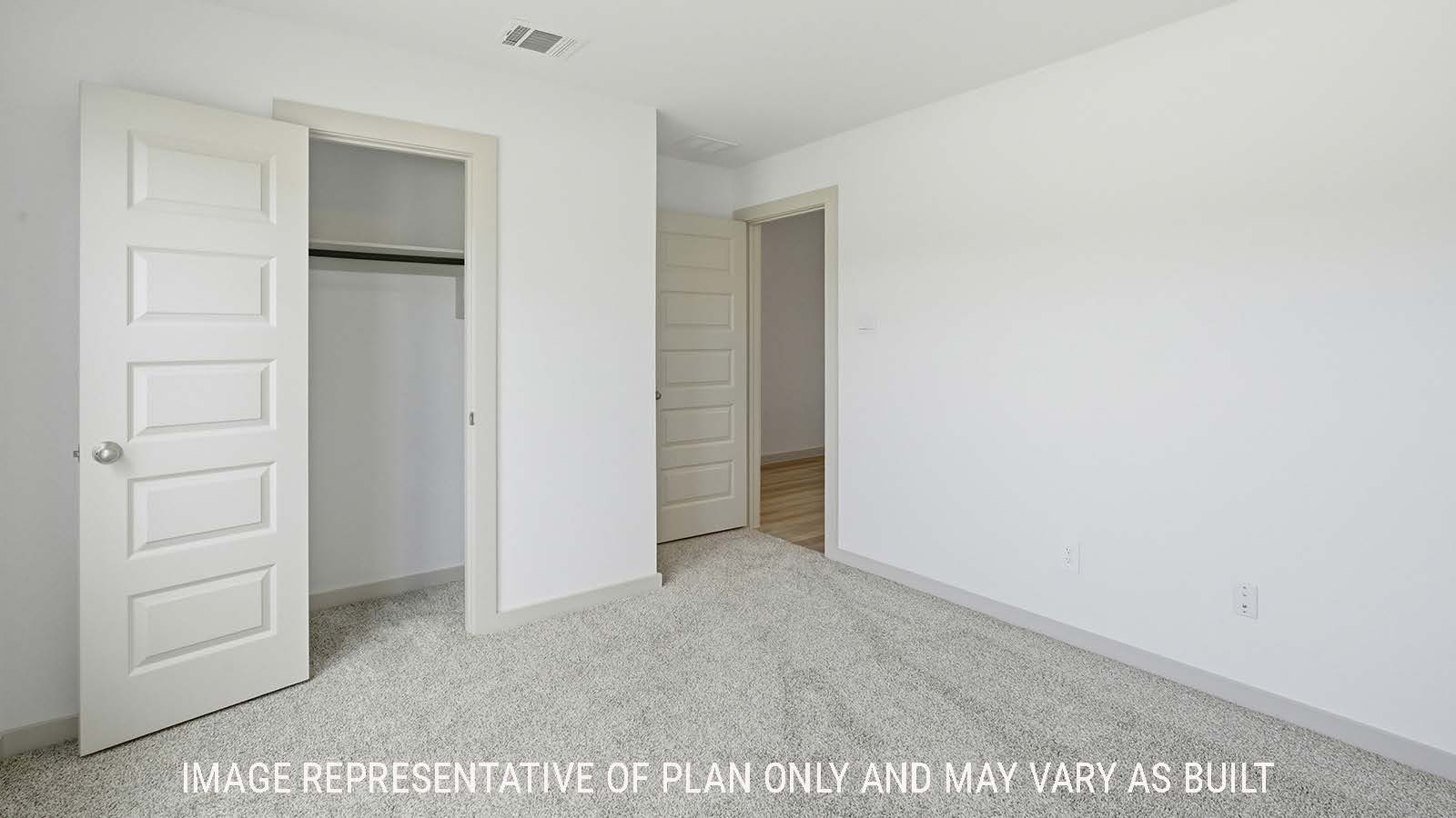 Texas Cali secondary bedroom with carpeted flooring and view of front hallway.