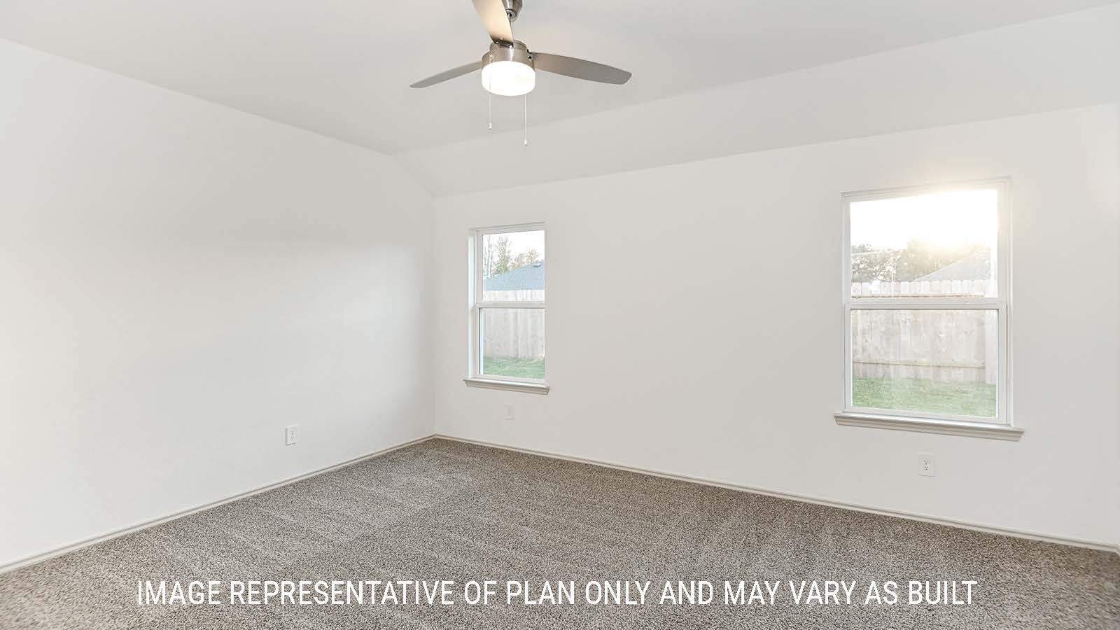 Lakeway primary bedroom with carpeted flooring and windows for natural lighting.
