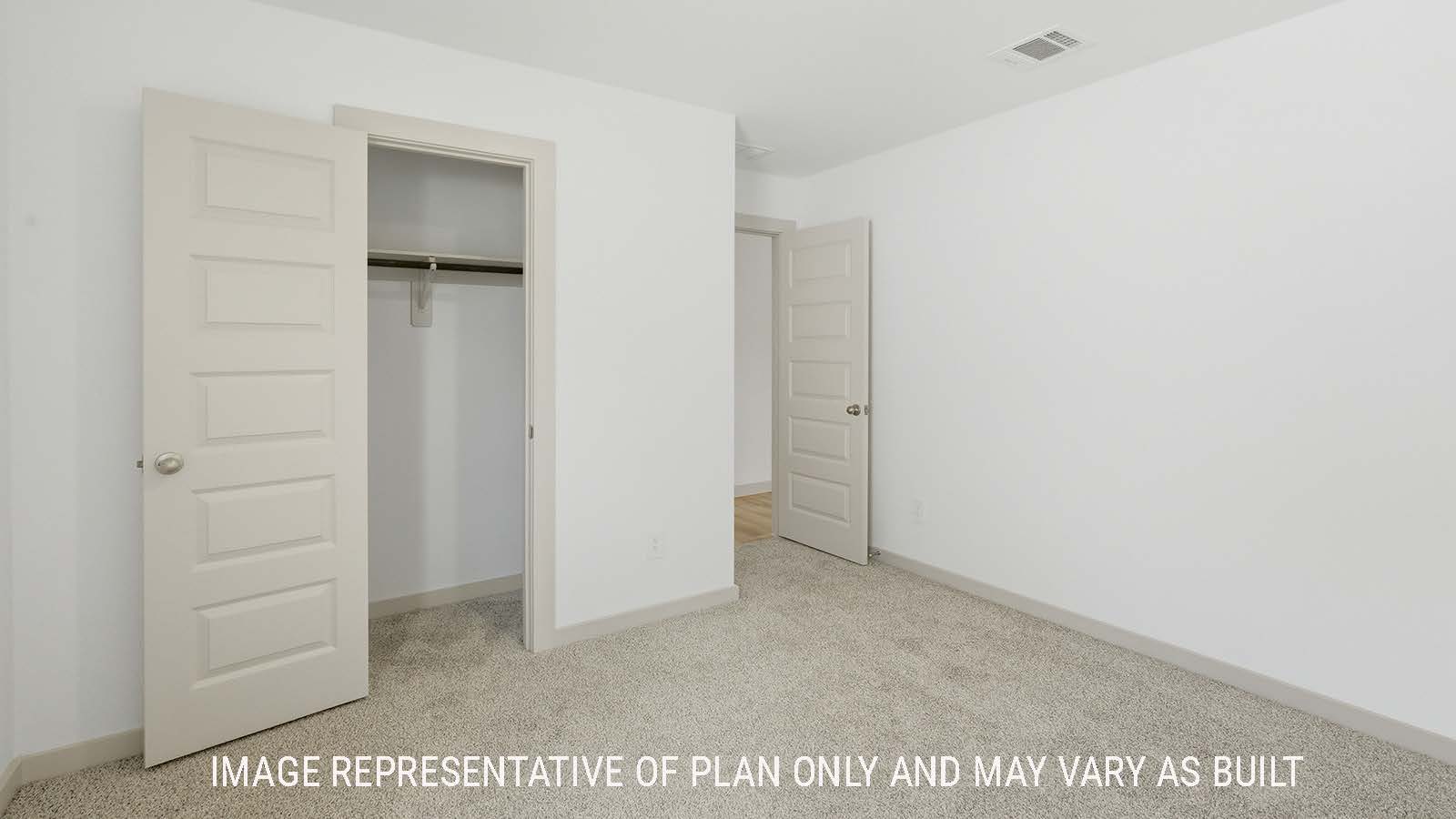 Lakeway secondary bedroom with carpeted flooring with view of open concept dining room.