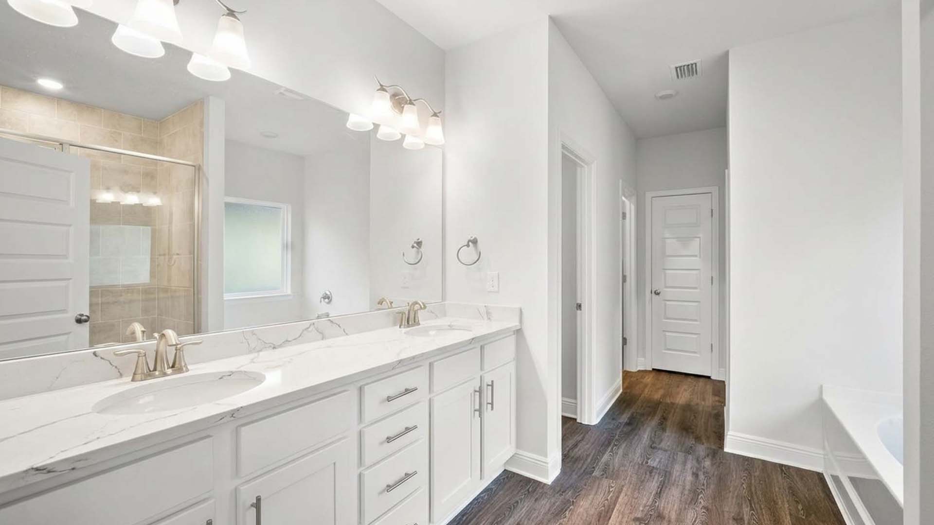 The primary bathroom has a dual sink vanity with lower cabinetry for storage