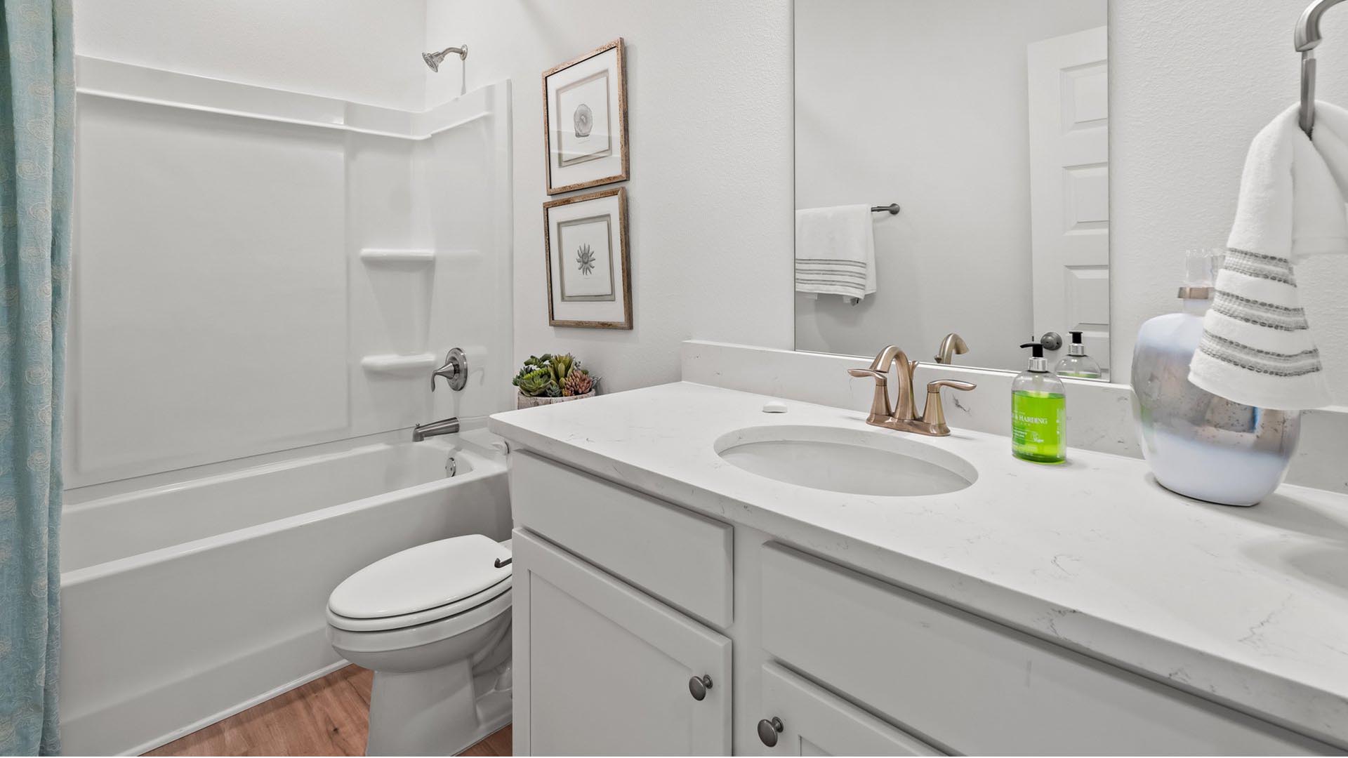 The shared bathrooms feature a single vanity with lower cabinetry and a shower tub combination
