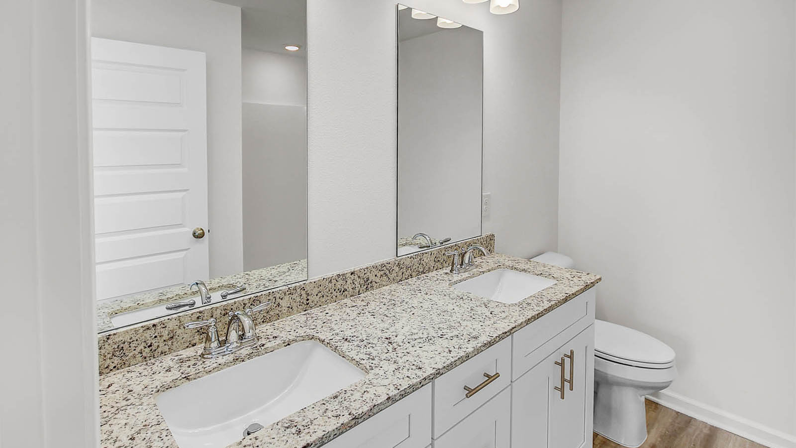The primary bathroom features a dual sink vanity with lower cabinetry