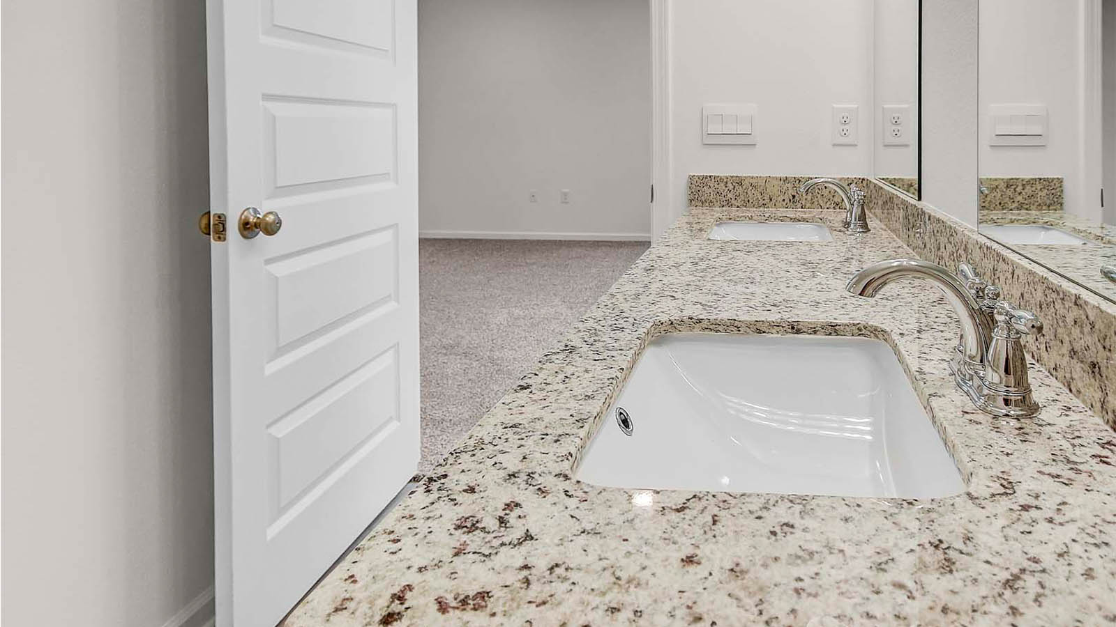 The primary bathroom is spacious and has granite counterto[s