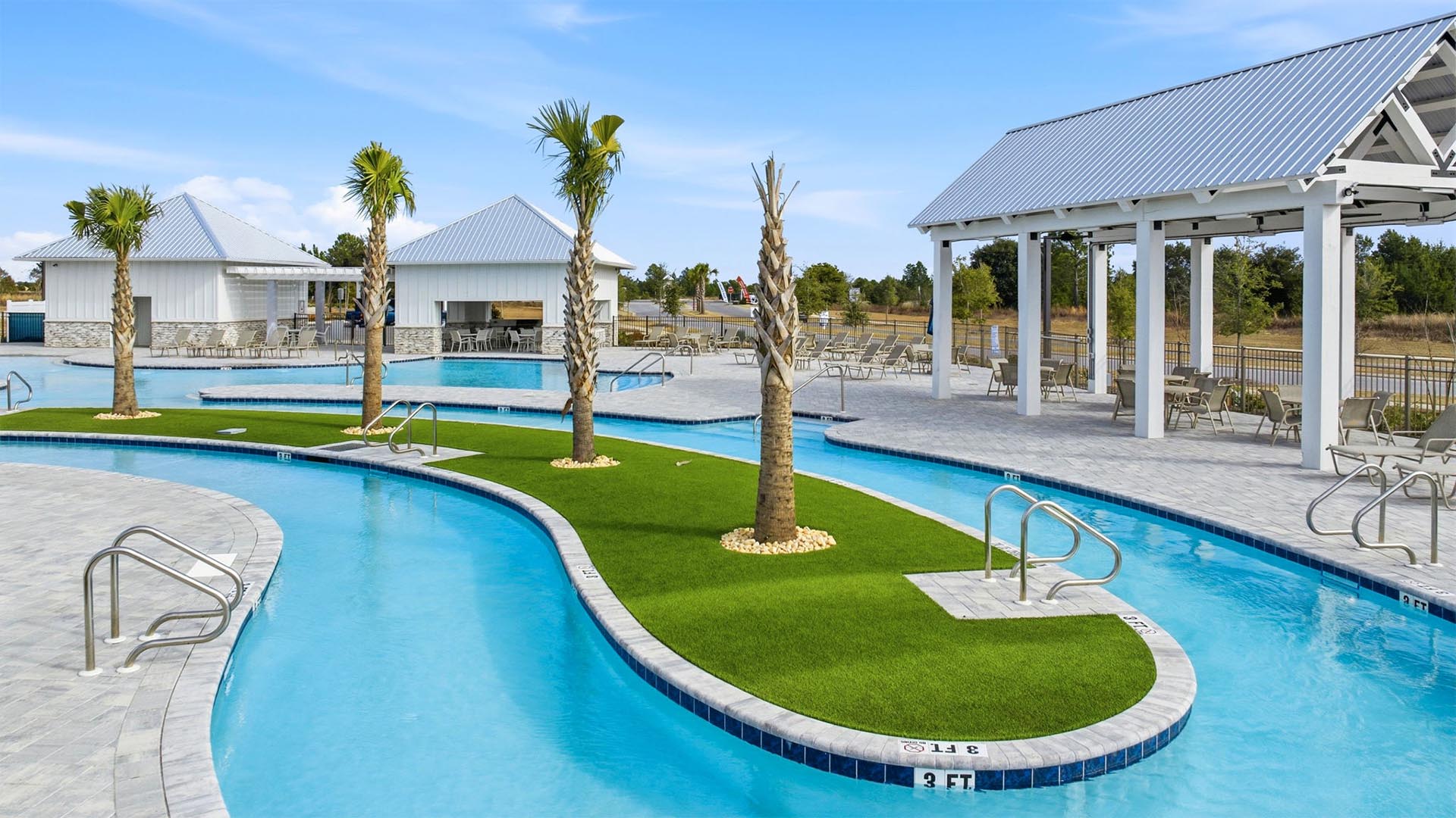 Lagoon style pool with an island that is landscaped with palm trees