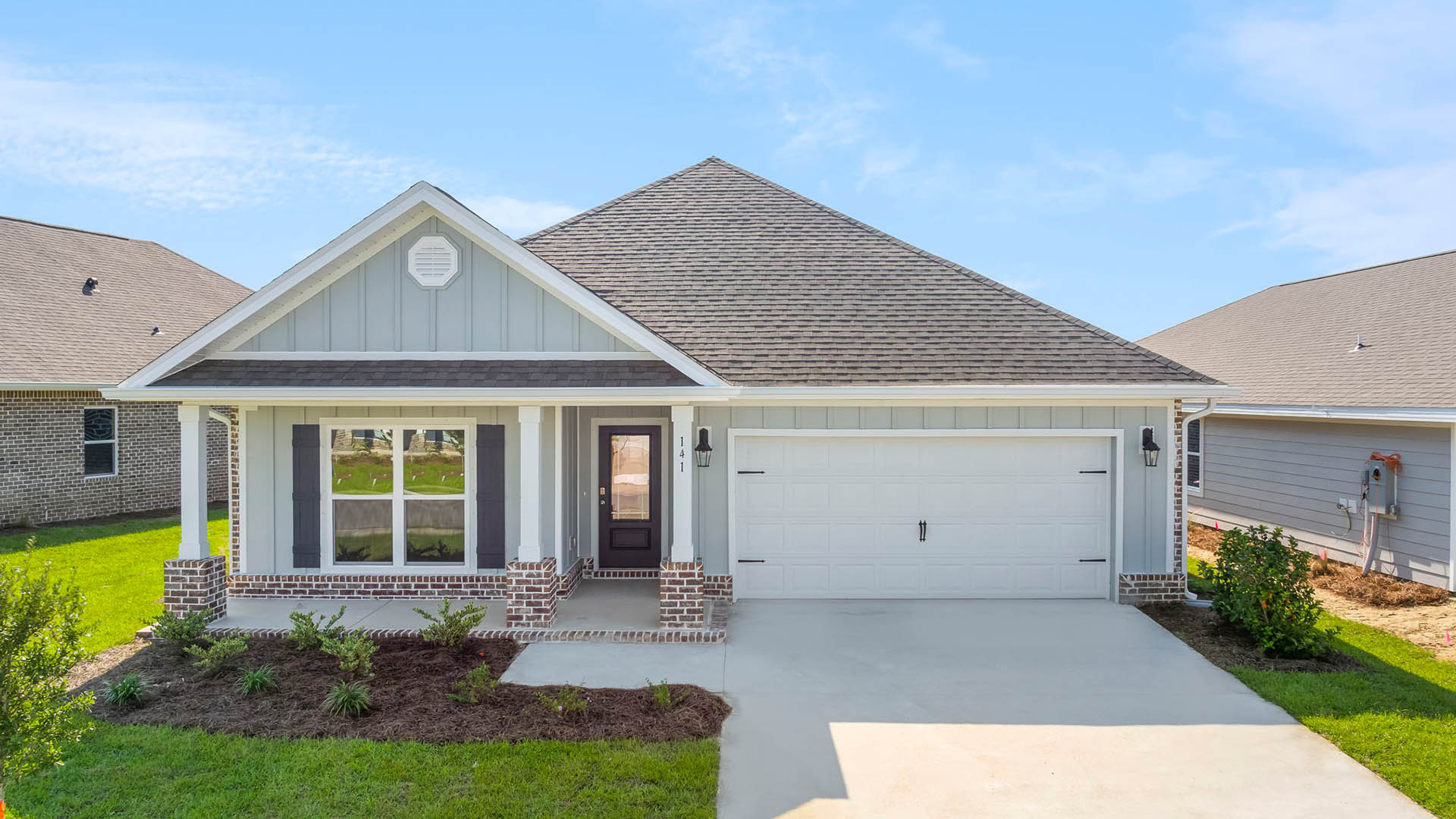 The Rhett floor plan has a covered front porch with Hardie siding and a brick skirt