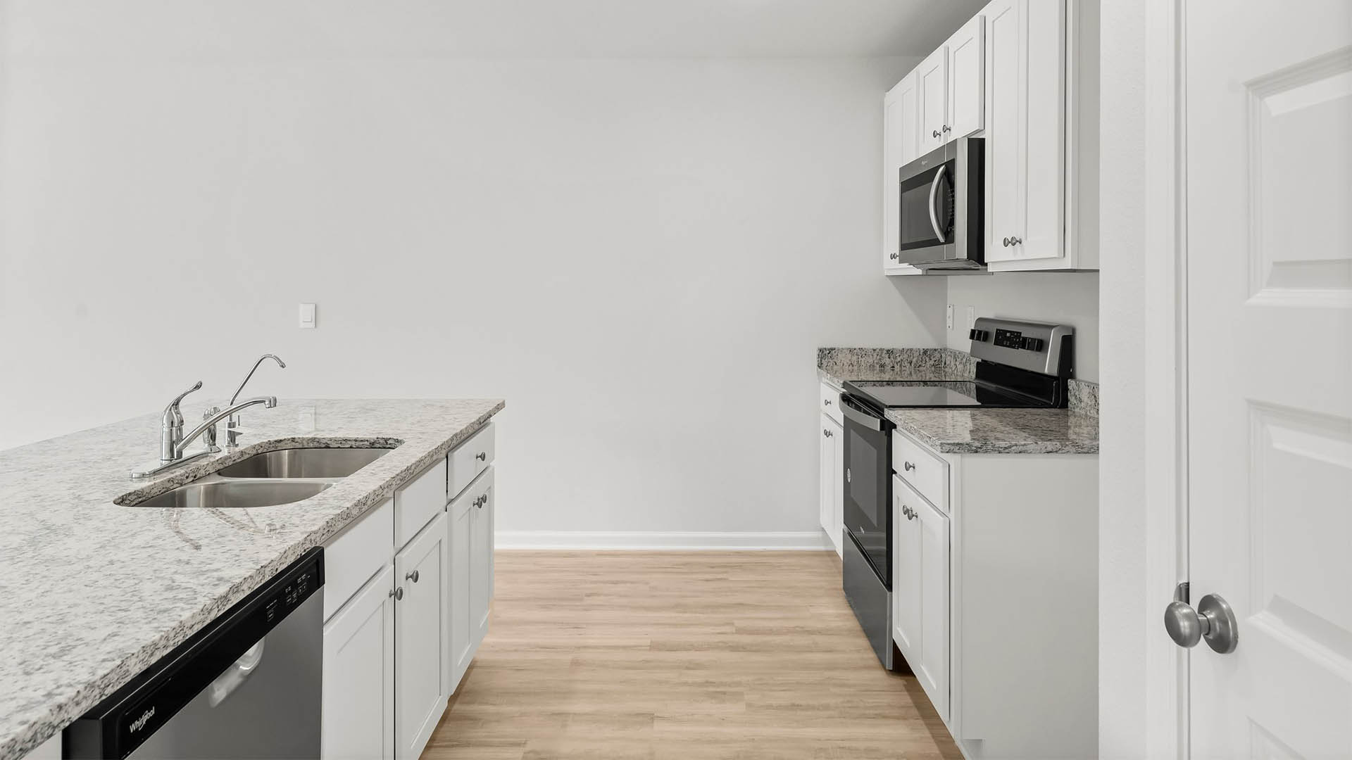 The kitchen features a stainless appliance package with smooth top stove microwave and dishwasher