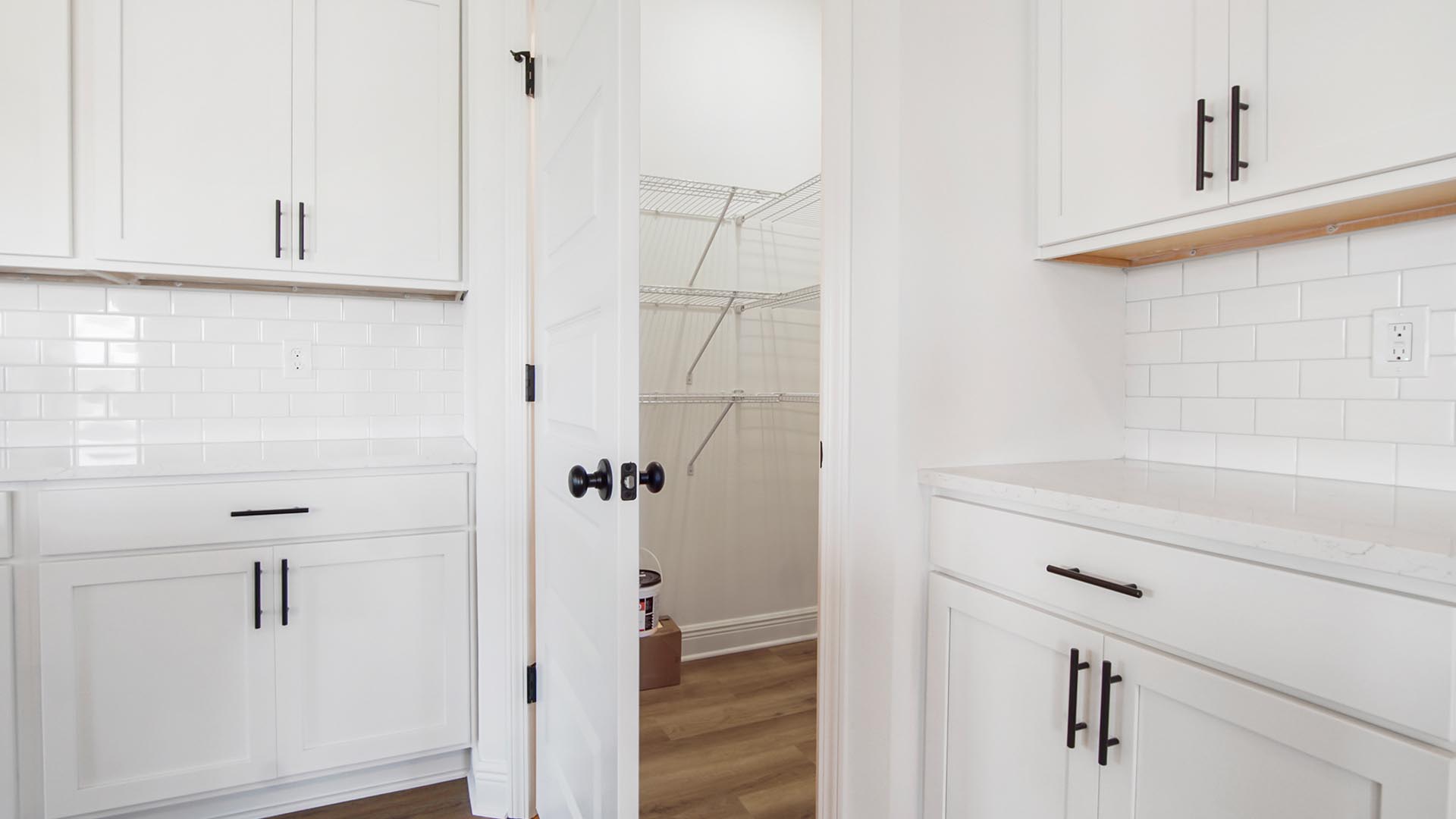 The kitchen has a corner pantry with shelving for storage
