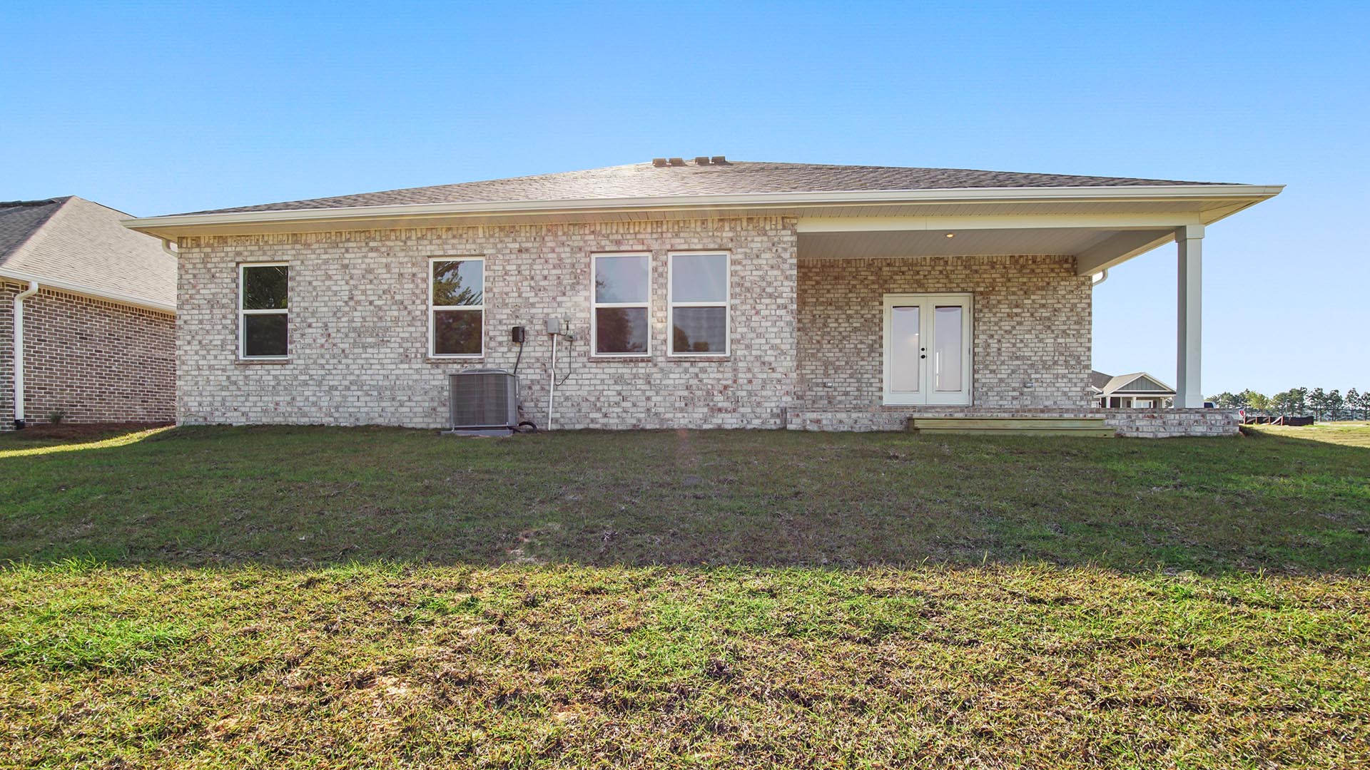Outside there is a covered patio at the back of the home with brick exterior