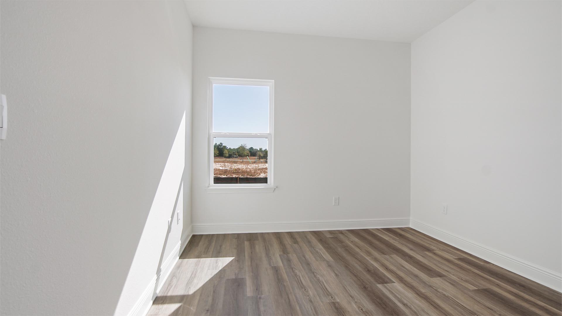 The guest bedroom features EVP flooring and a spacious closet