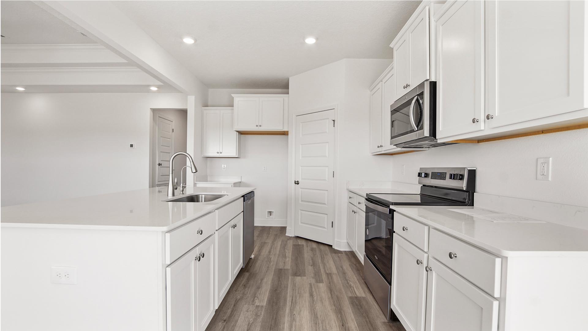 The kitchen has a pantry and upper and lower cabinetry for storage
