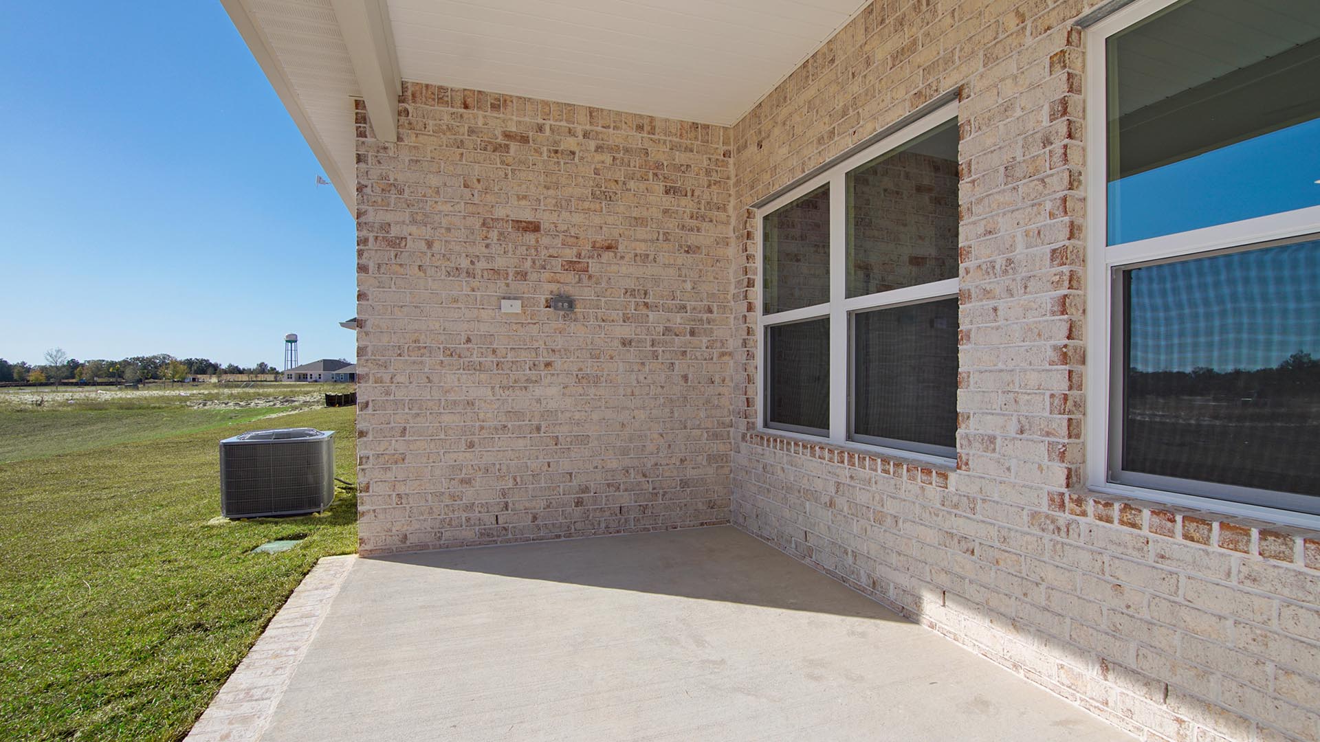 The back of the home has a covered patio with brick on all three sides. The front exterior has Hardie with brick skirt
