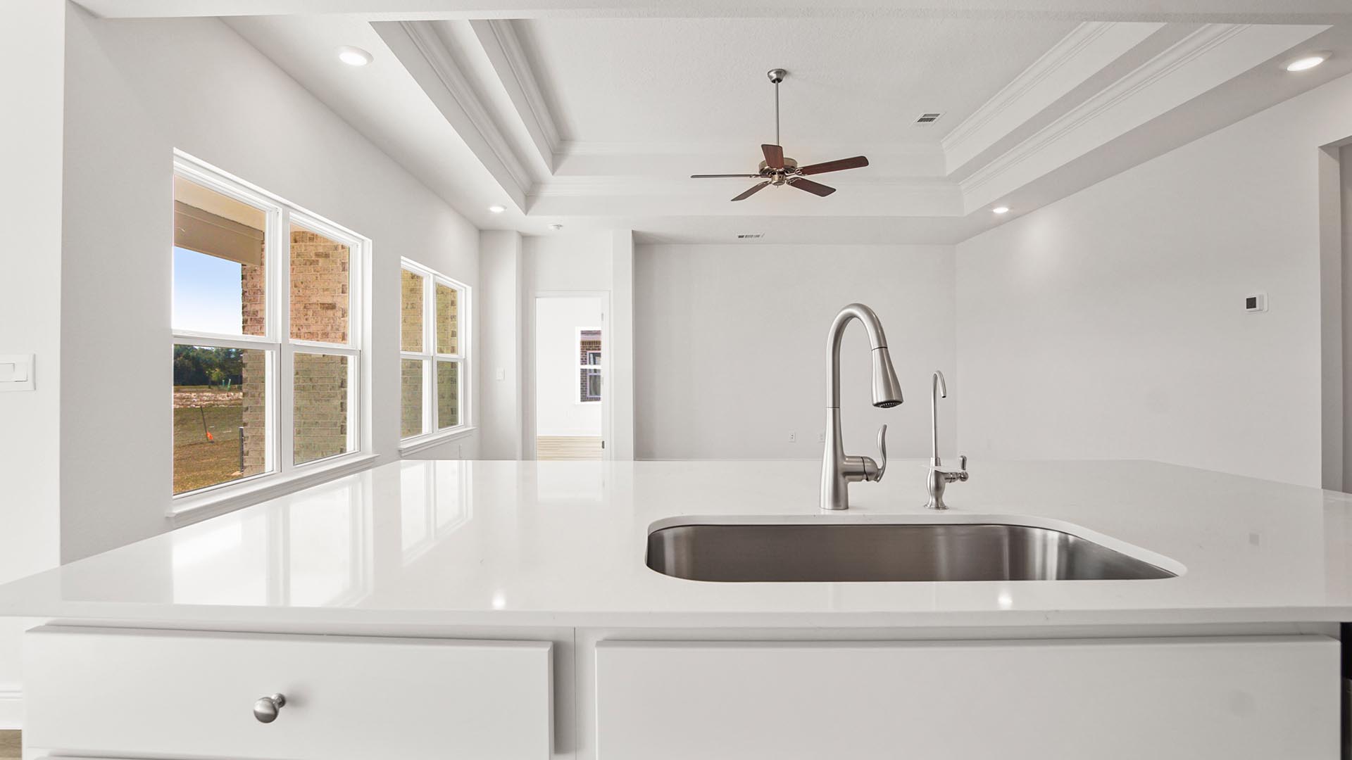 The center island has lower cabinetry, a sink and dishwasher