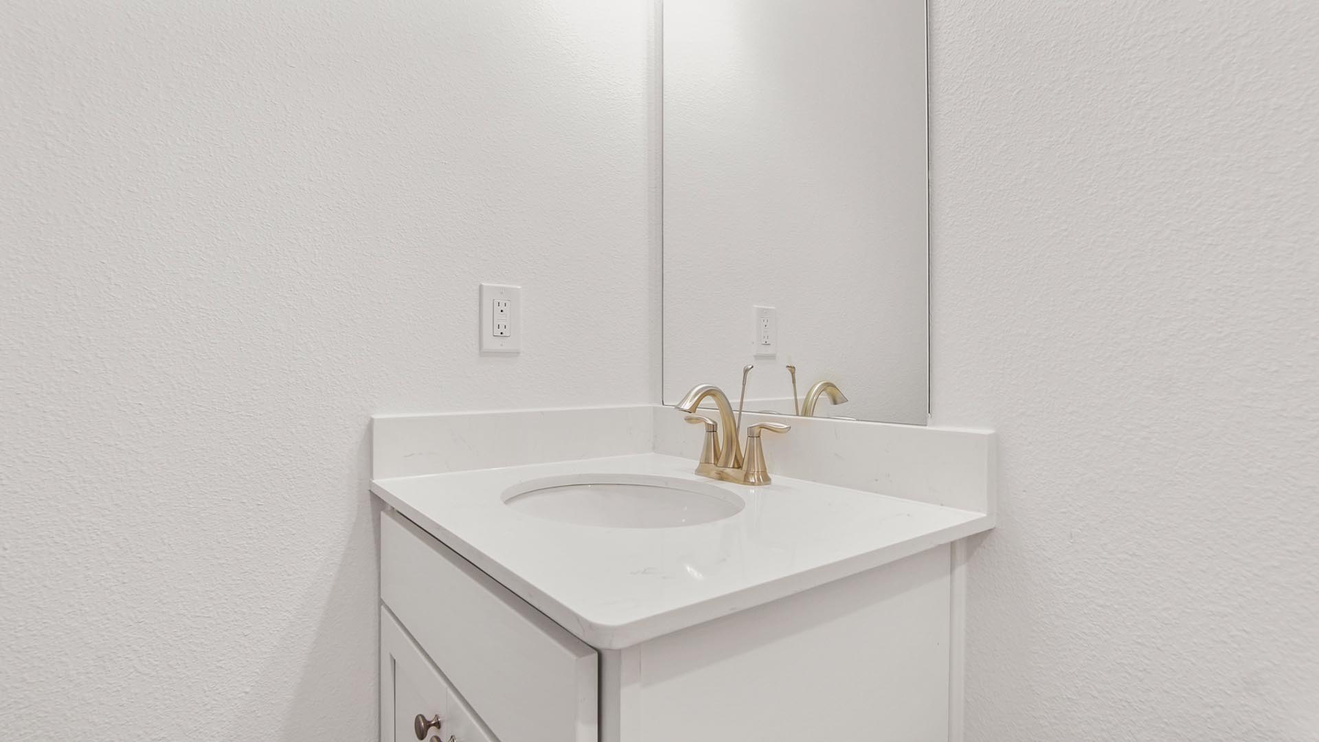 The bathroom in bedroom four has a vanity with quartz countertops