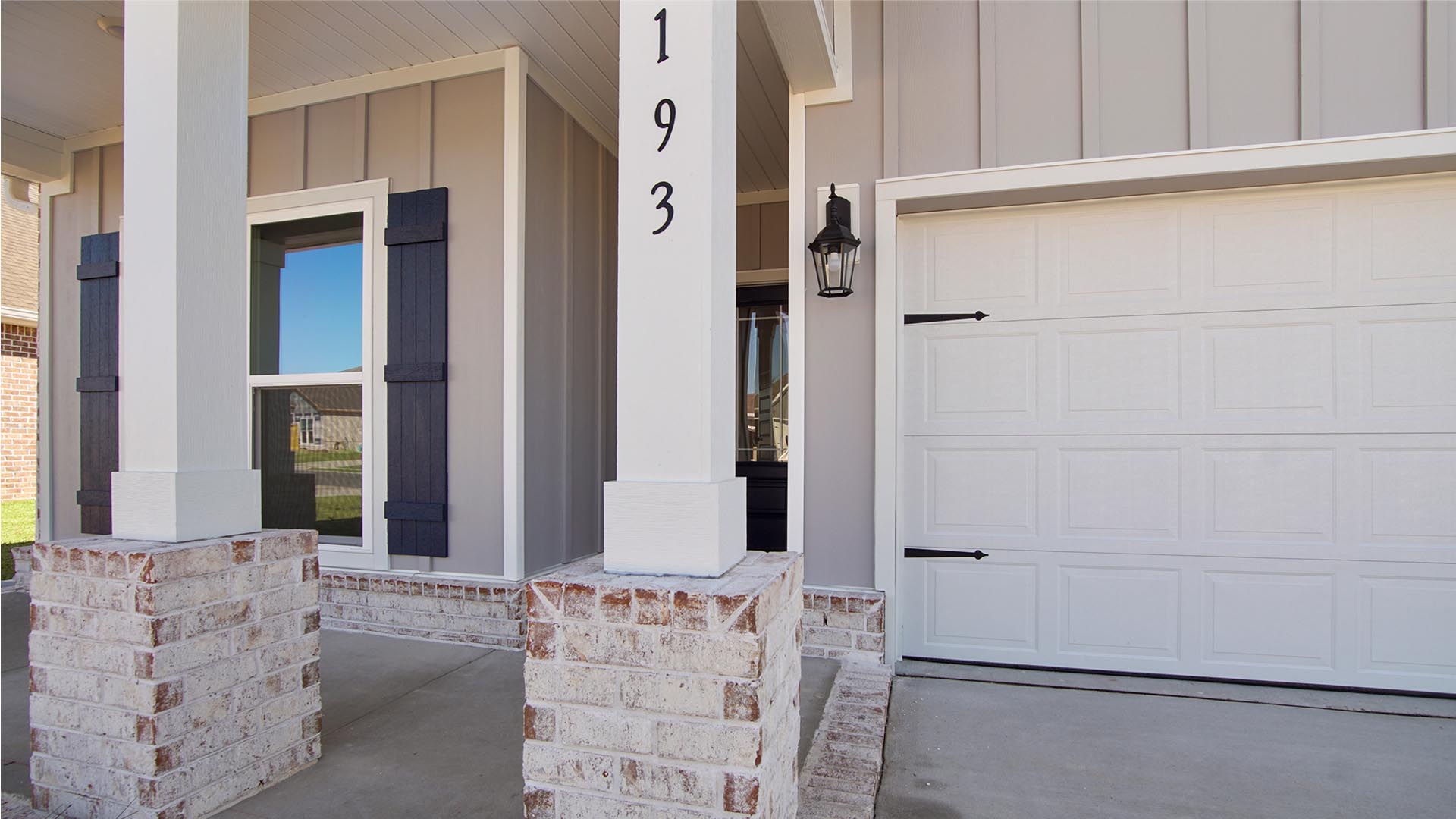 Covered entry leading to the front door with columns that have a brick skirt