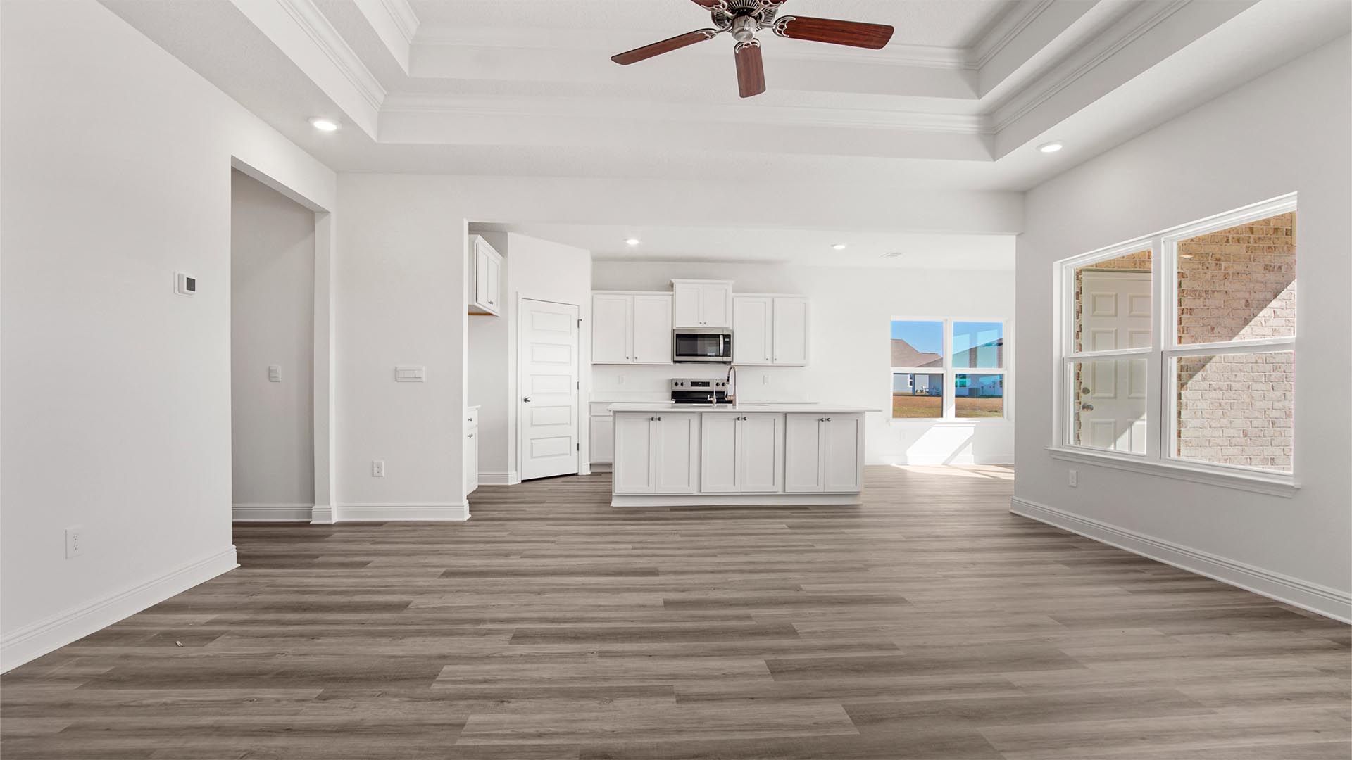 Living area with EVP flooring that is open to the kitchen and breakfast area