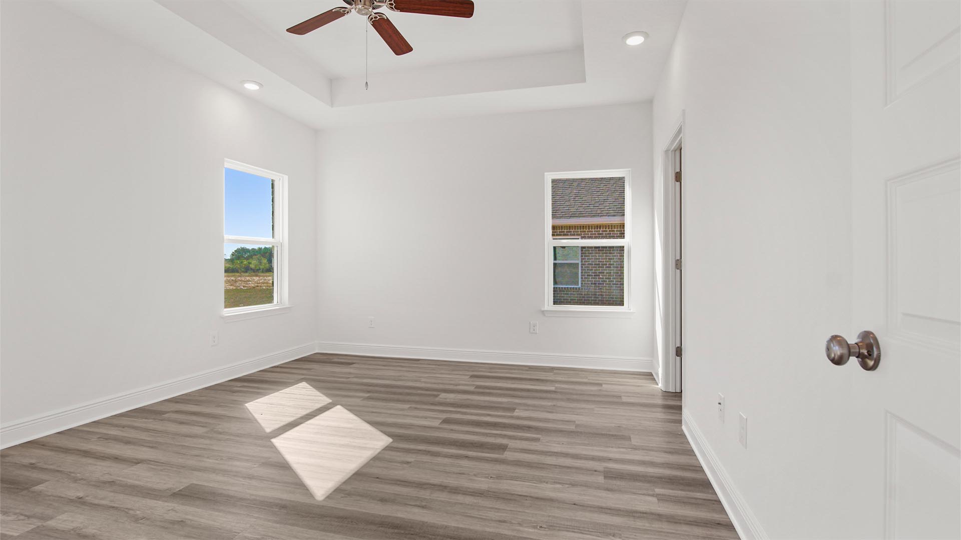 The primary bedroom features EVP flooring trey ceilings and an overhead fan