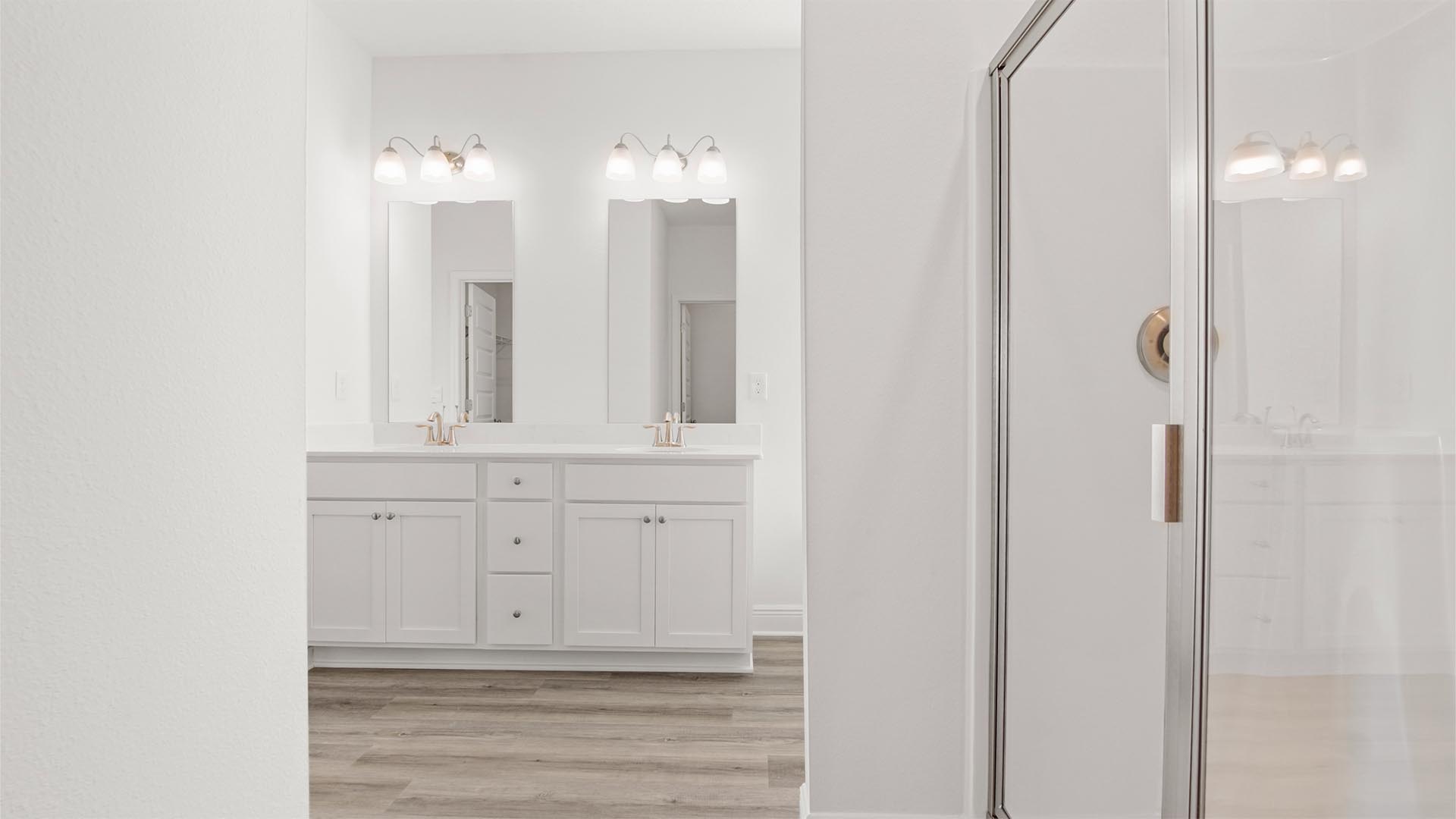 The primary bathroom is luxurious with quartz countertops and EVP flooring