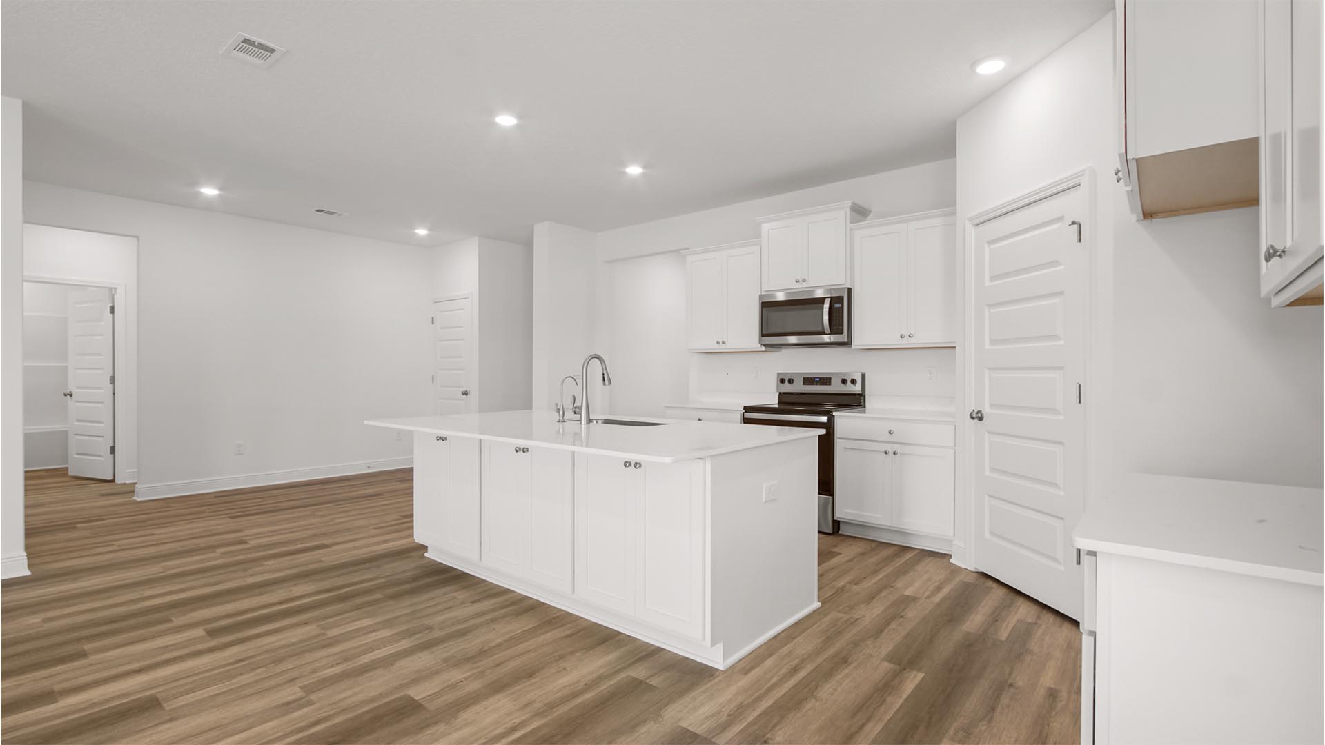The kitchen has beautiful white cabinetry with upper and lower storage optons