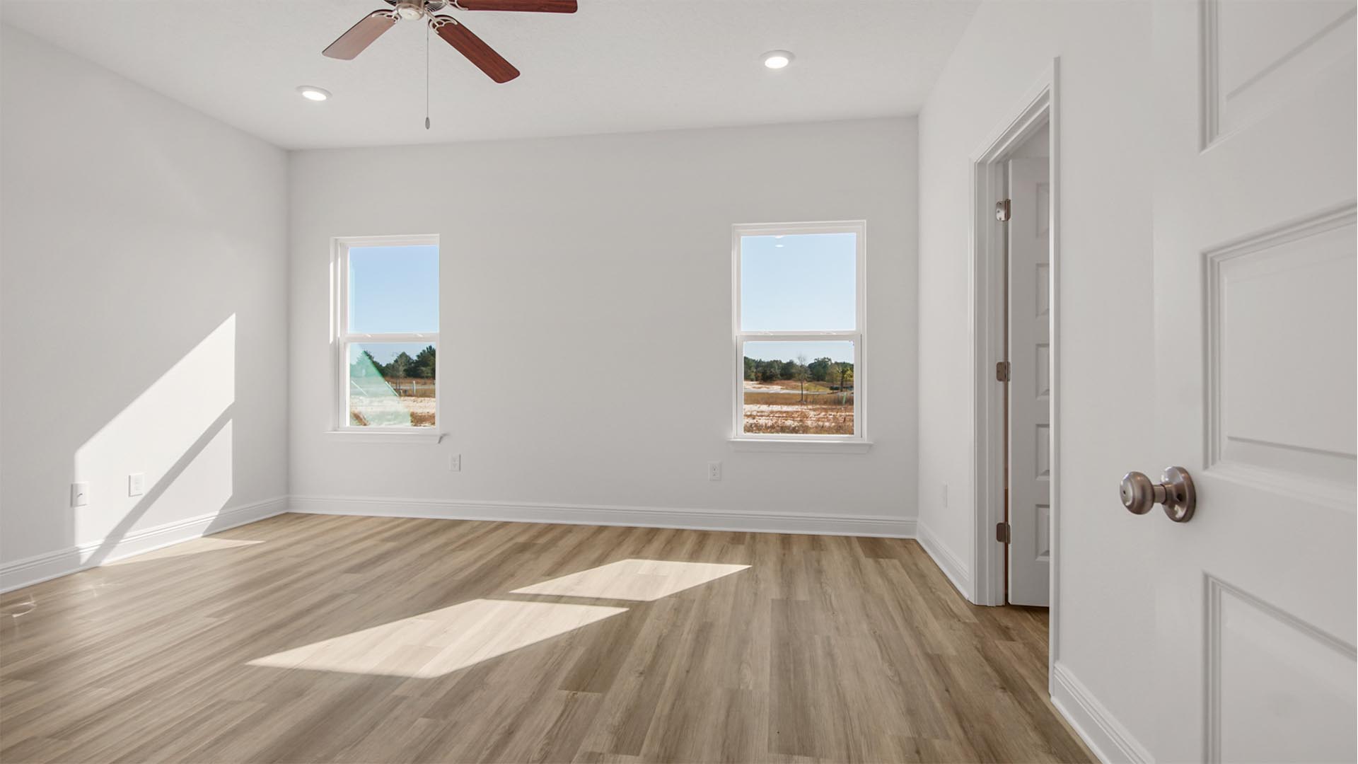 Primary bedroom is spacious and features a ceiling fan for comfort