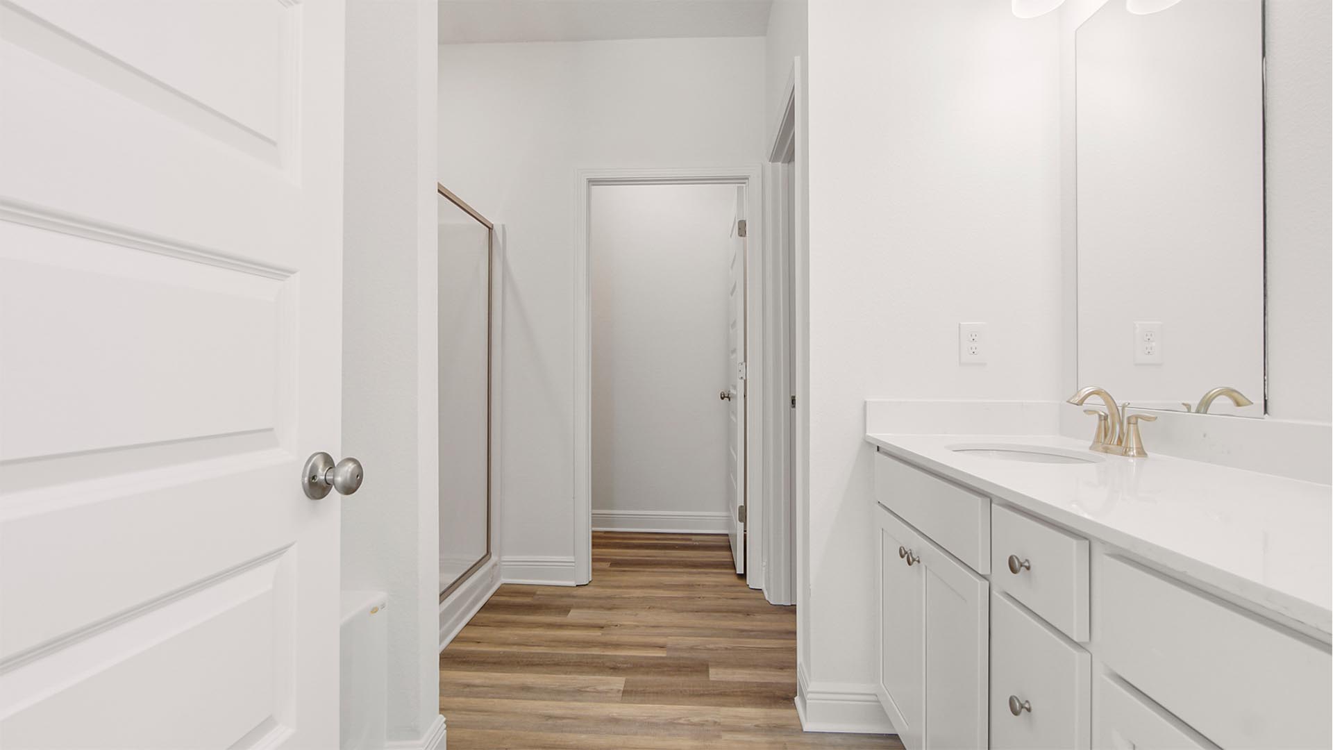 The primary bathroom has EVP flooring and quartz countertops