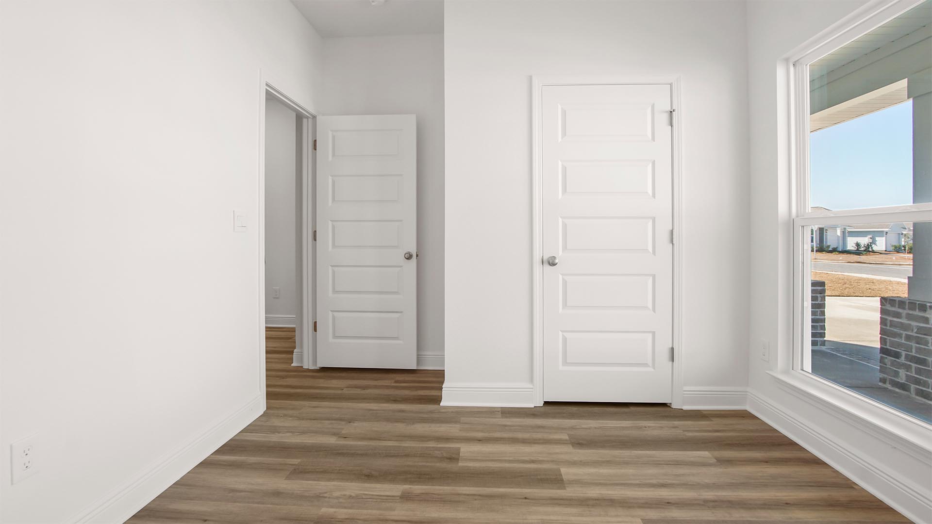 Bedroom five is located at the front of the home and overlooks the covered porch area